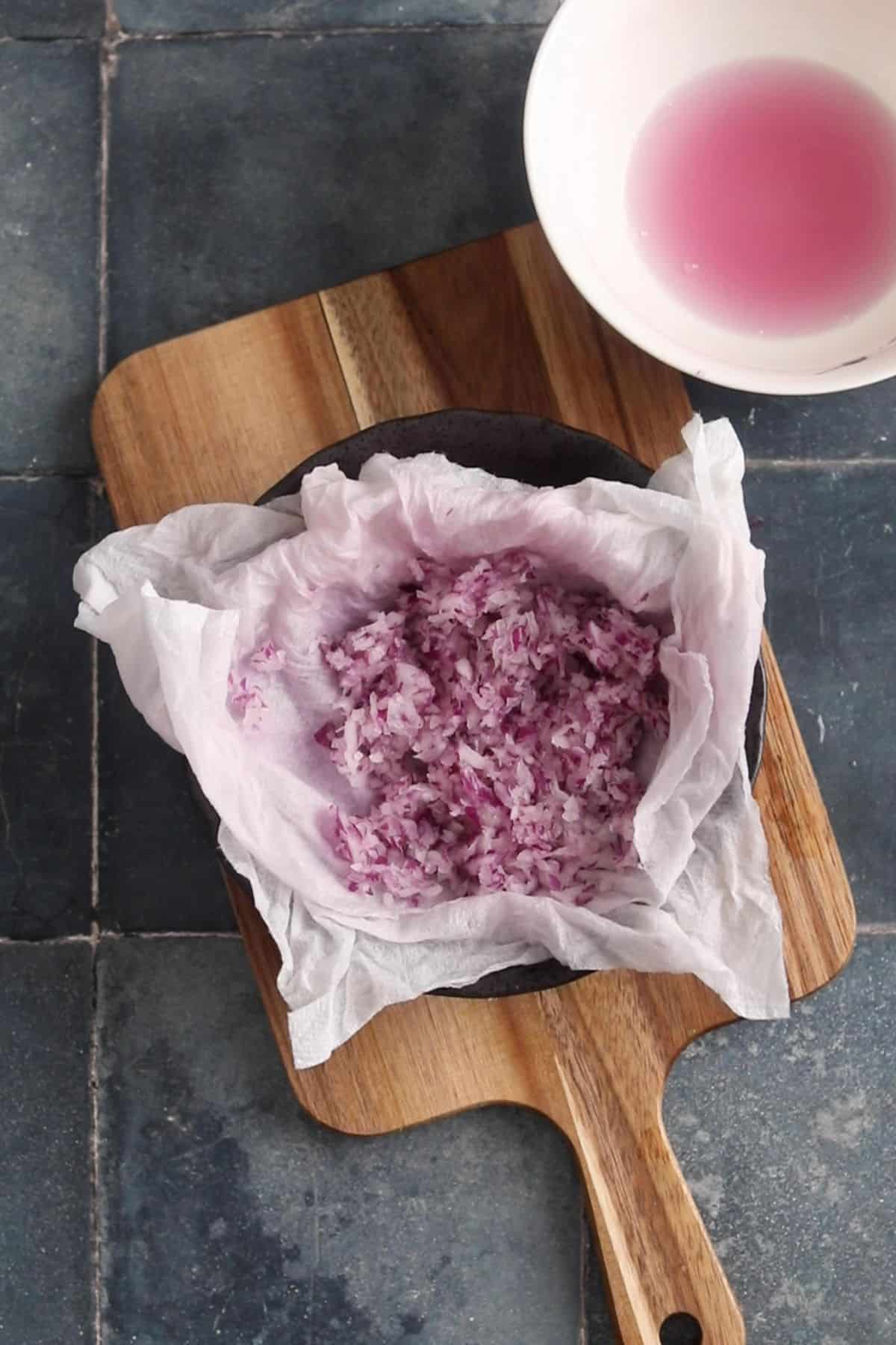 Squeezed onions with onion juice in a white bowl.