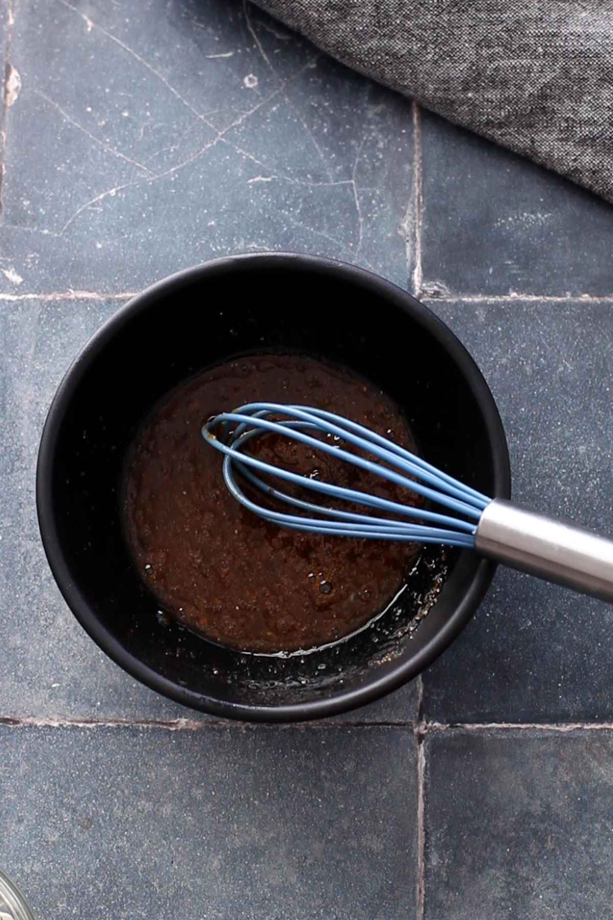 Chicken marinade whisked in a black bowl.