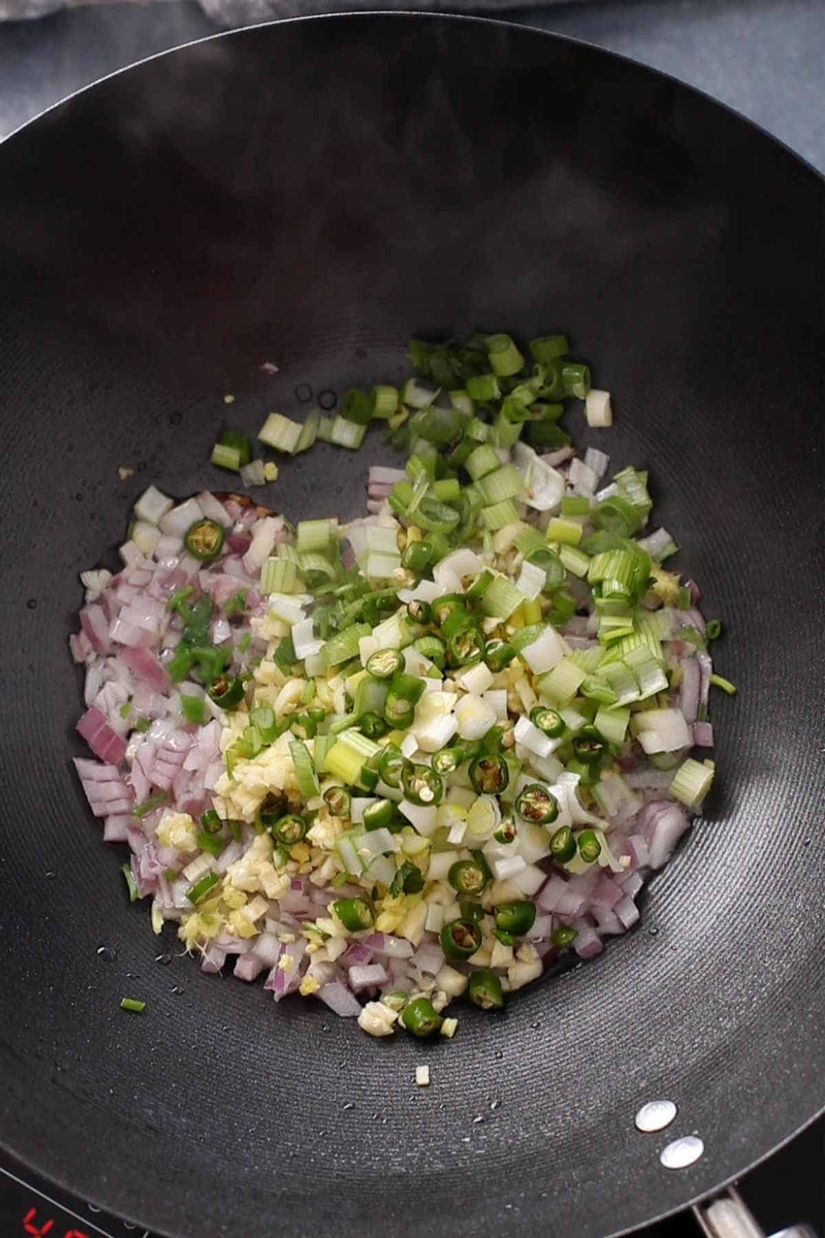 Stir frying vegetables in a wok. 