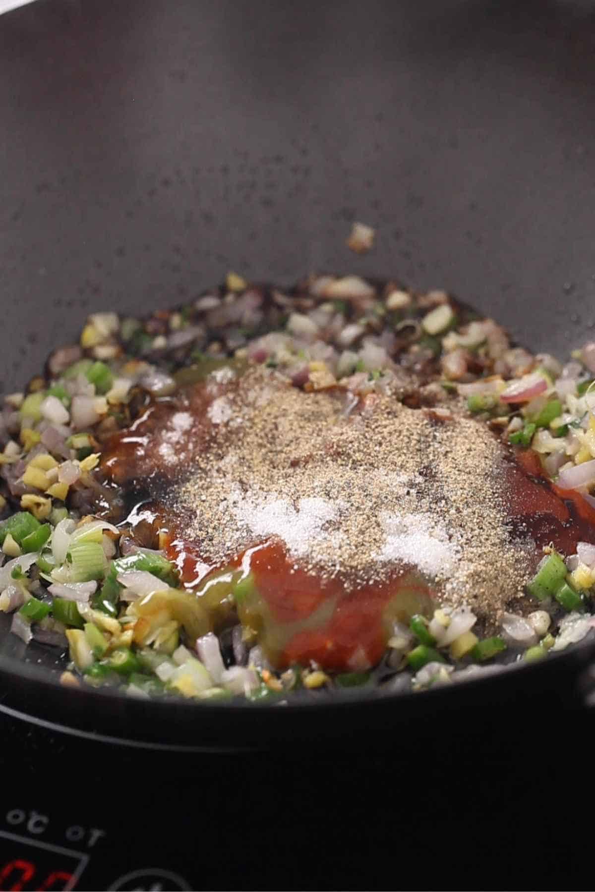 Adding indo chinese condiments to the wok. 
