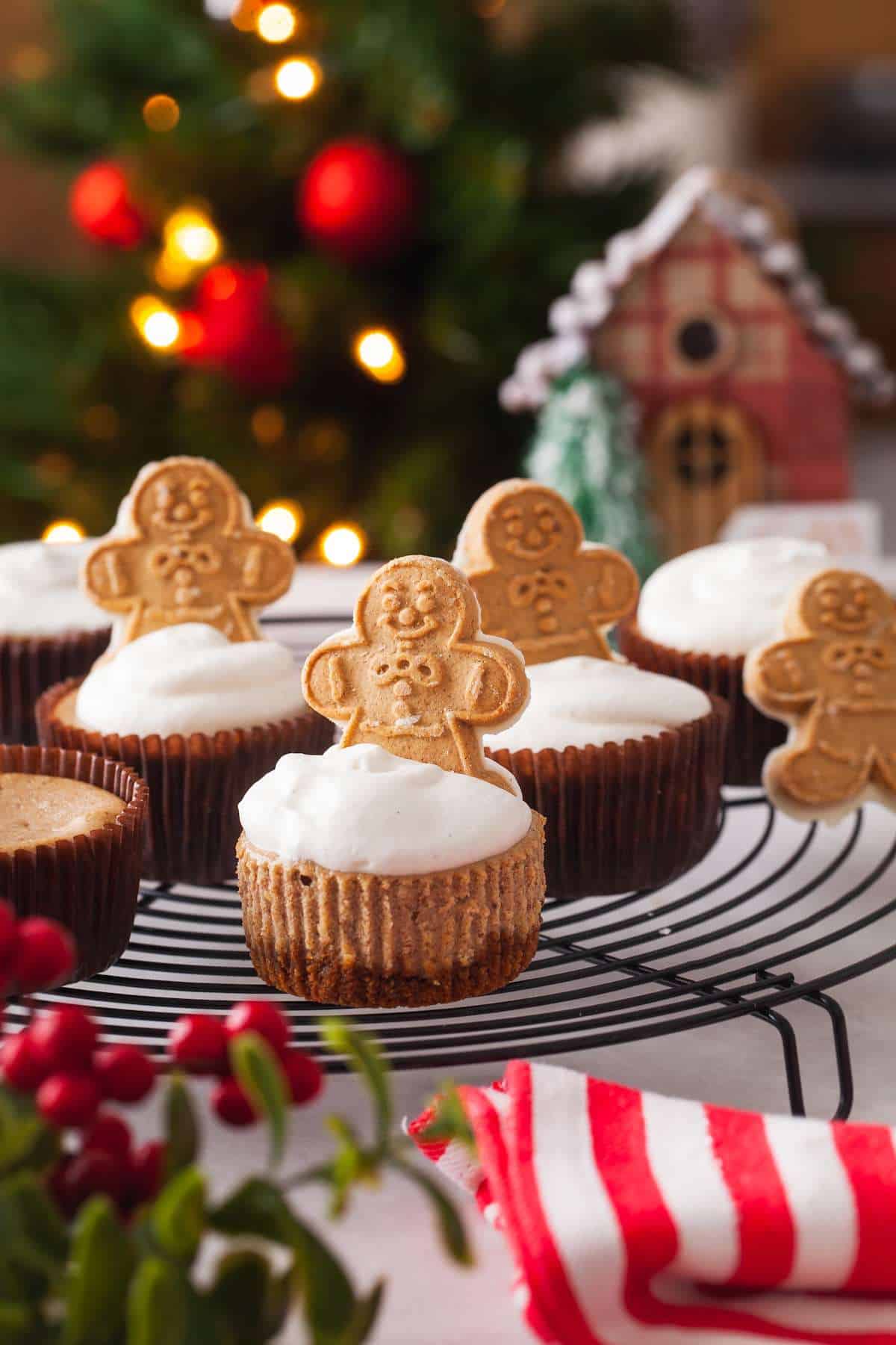 Mini Gingerbread Cheesecakes decorated with ginger bread cookies on a wire rack. 