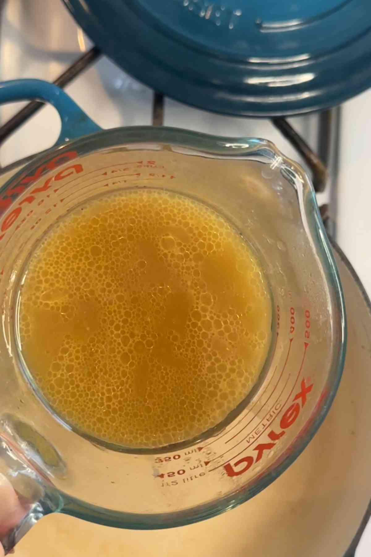 Yakhni in a measuring cup.