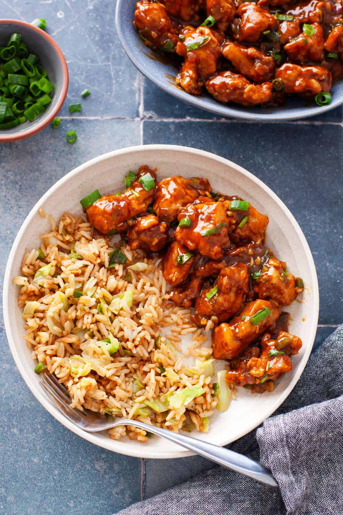 Chicken manchurian served with fried rice in a beige bowl.