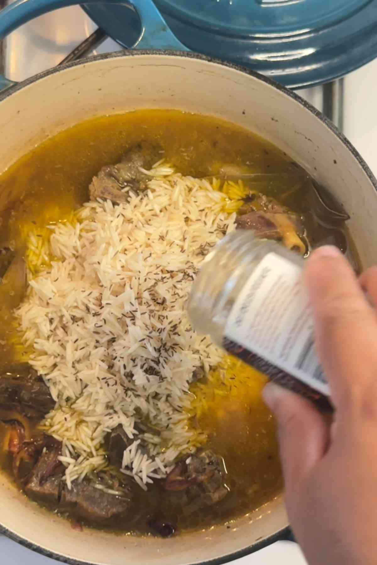 Adding cumin to rice.