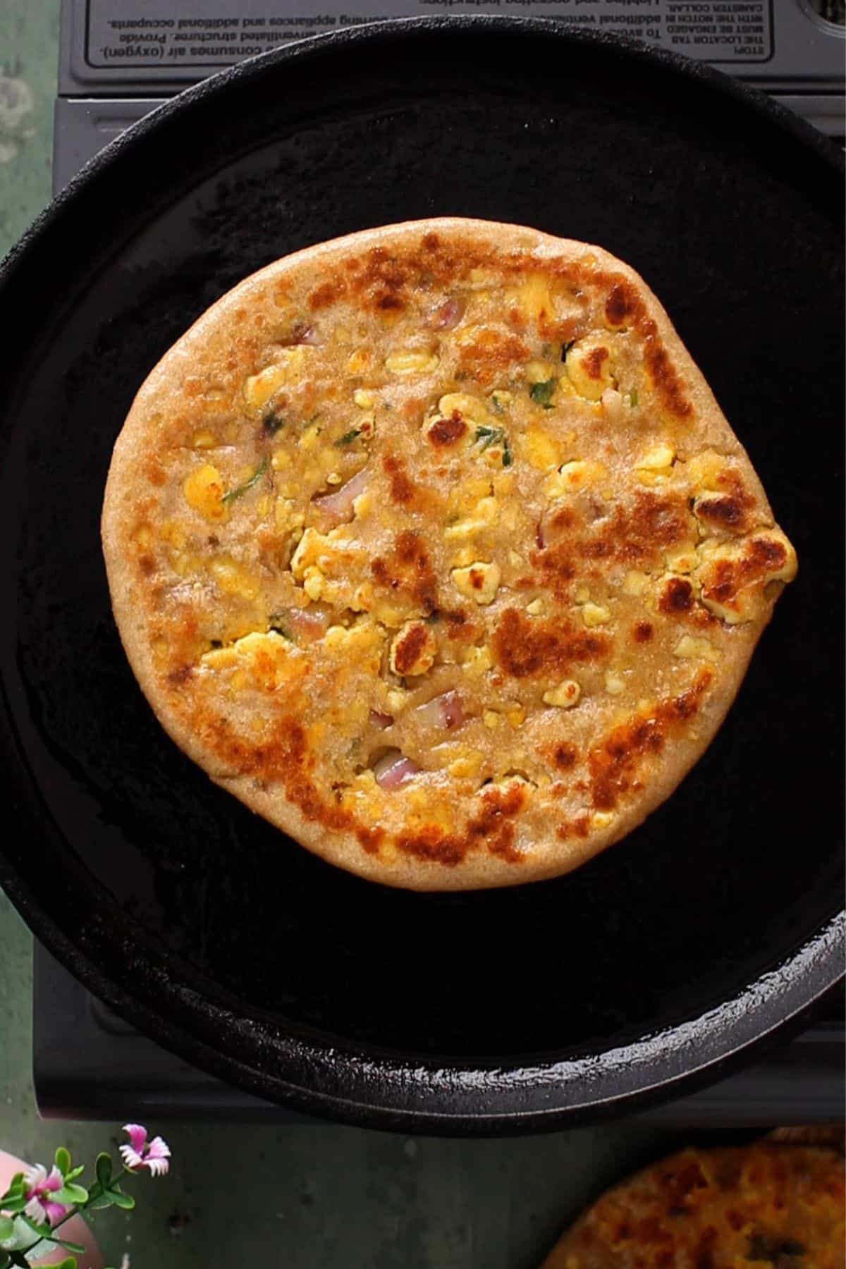 Stuffed paneer paratha is cooked until golden and is ready to serve.
