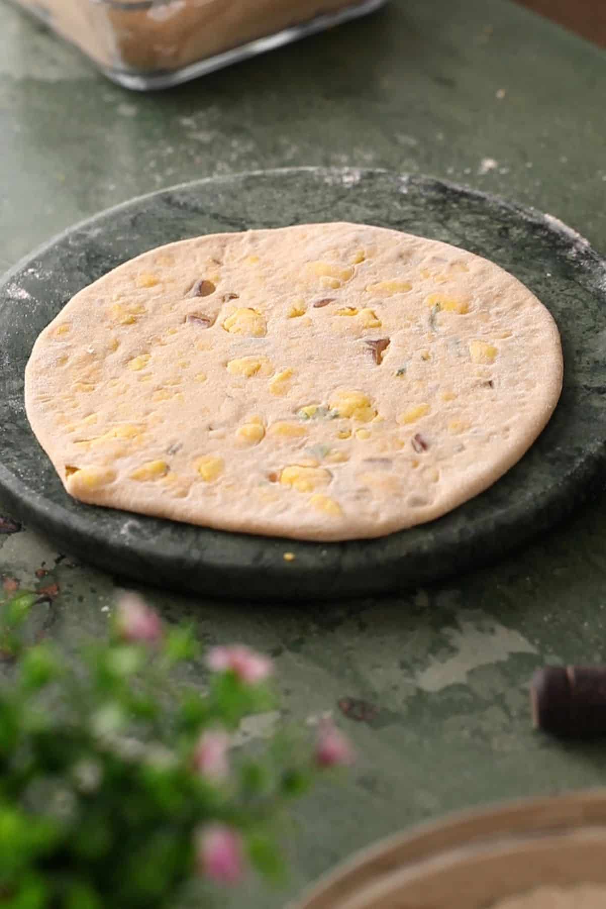 Paneer paratha is rolled using rolling pin and ready to cook.