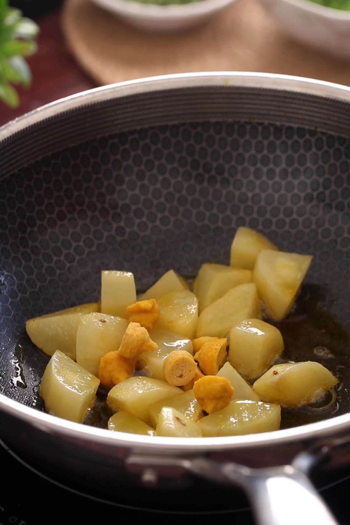 Shallow frying potatoes and dried dal wadi in oil.