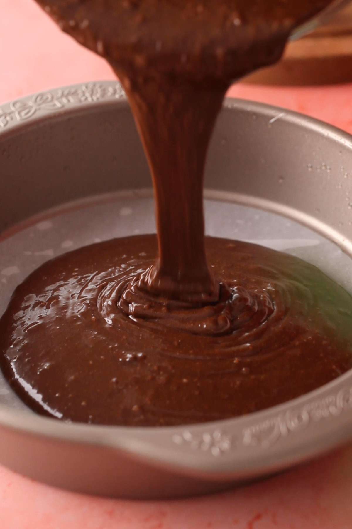 Pouring chocolate cake batter in the cake pan.