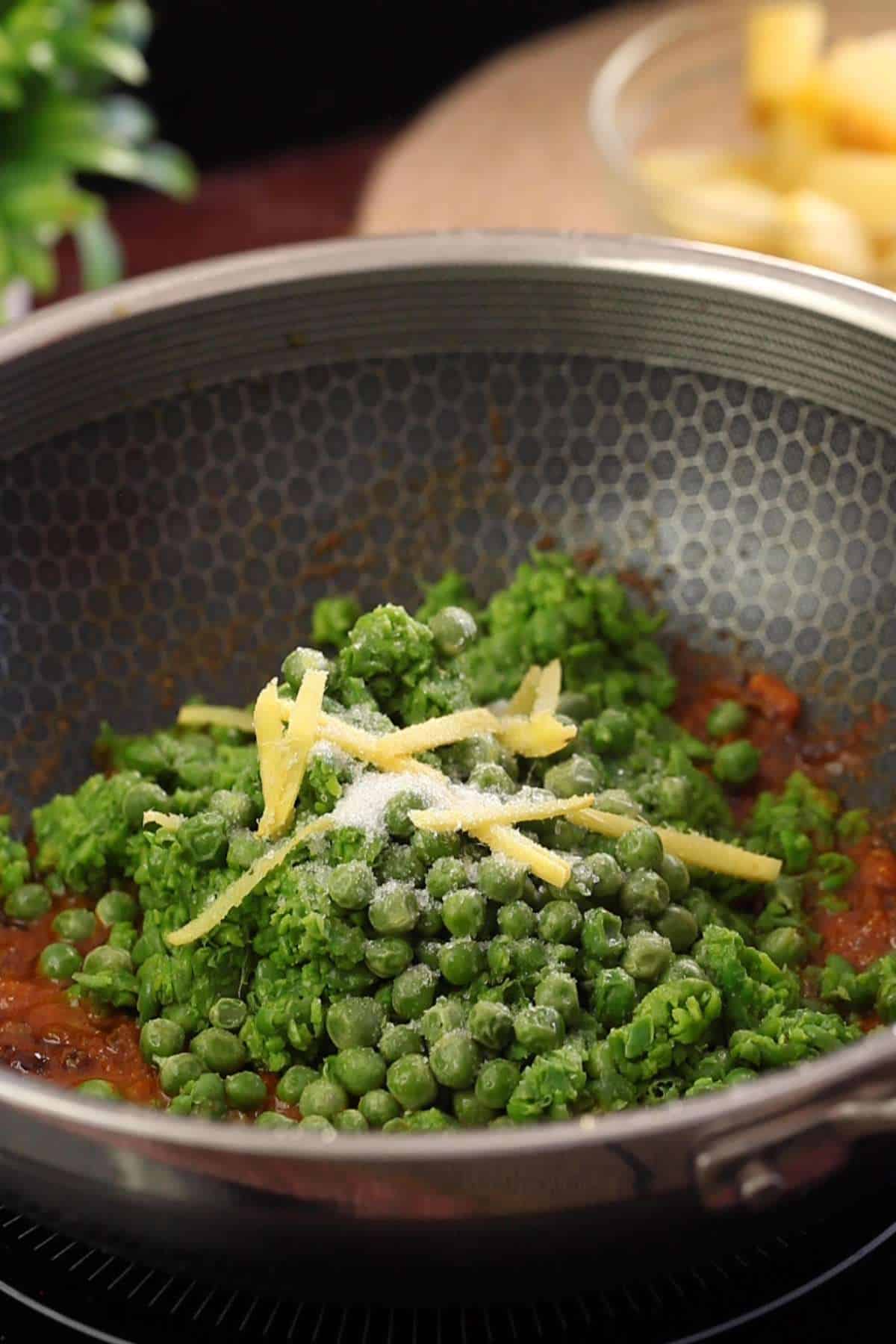 Coarse green peas paste, whole peas and ginger are added to the masala.