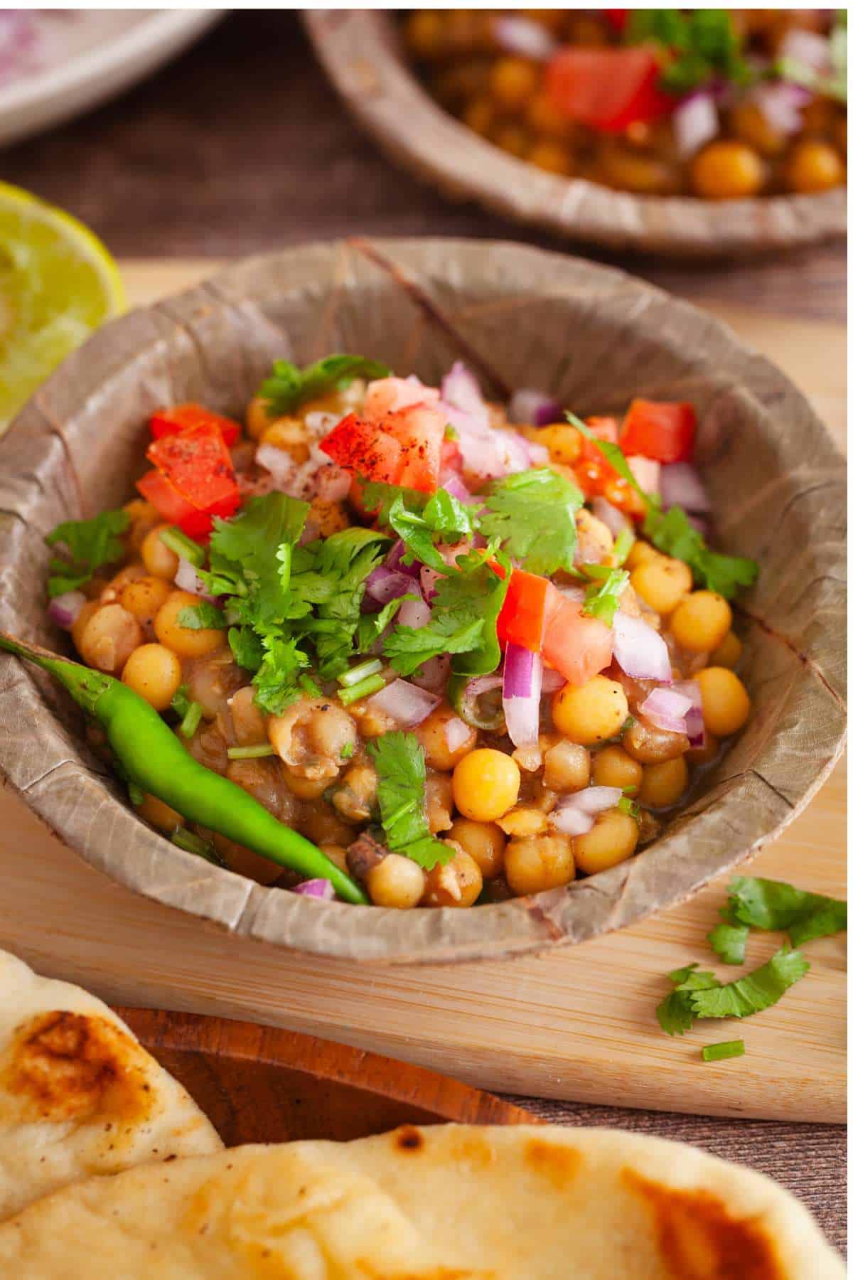 Close up shot of Matar Kulcha chaat served in a leaf bowl.