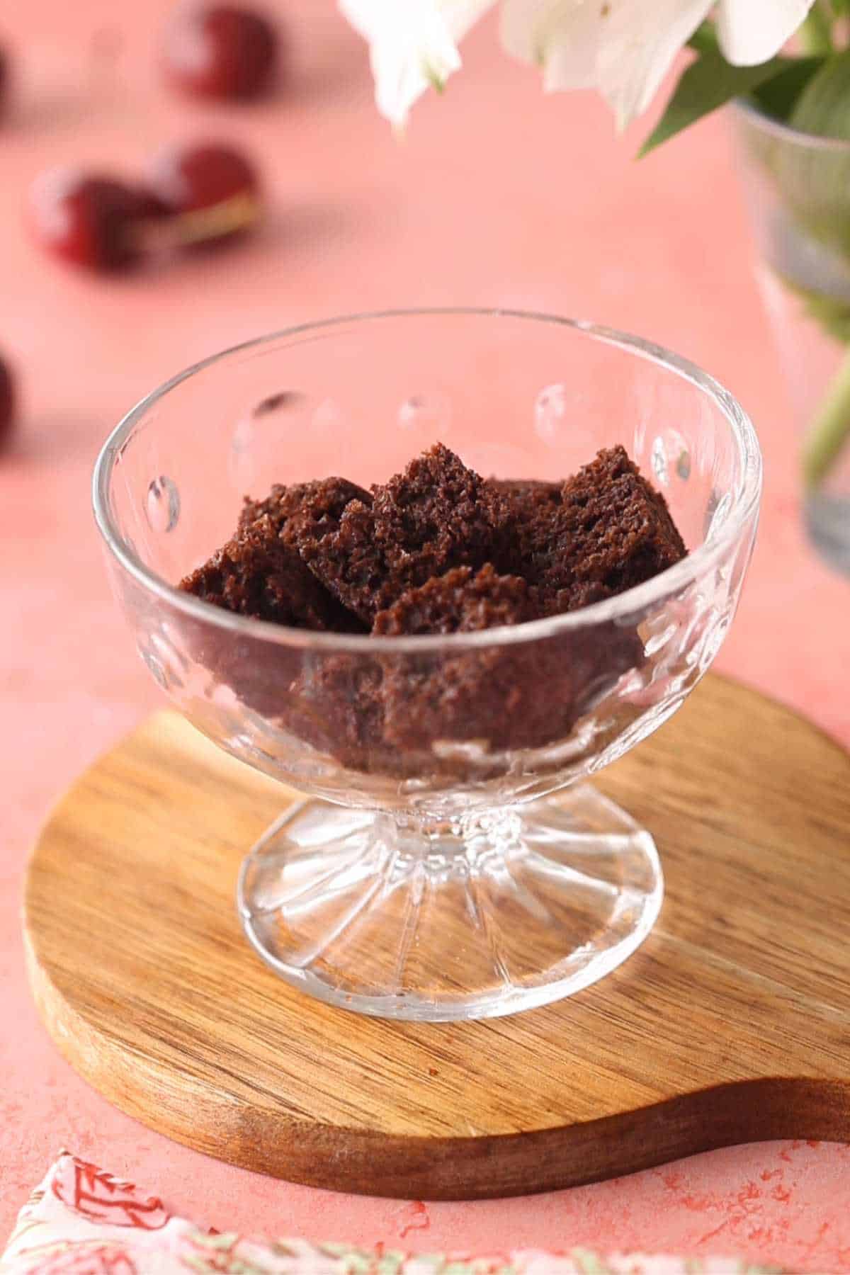 Layer of chocolate cake in a glass serving bowl.
