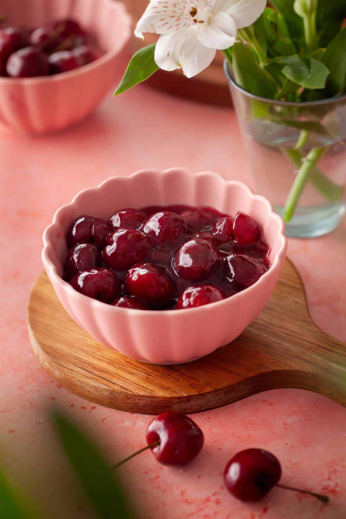 Fresh cherry pie filling in a fluted pink bowl.