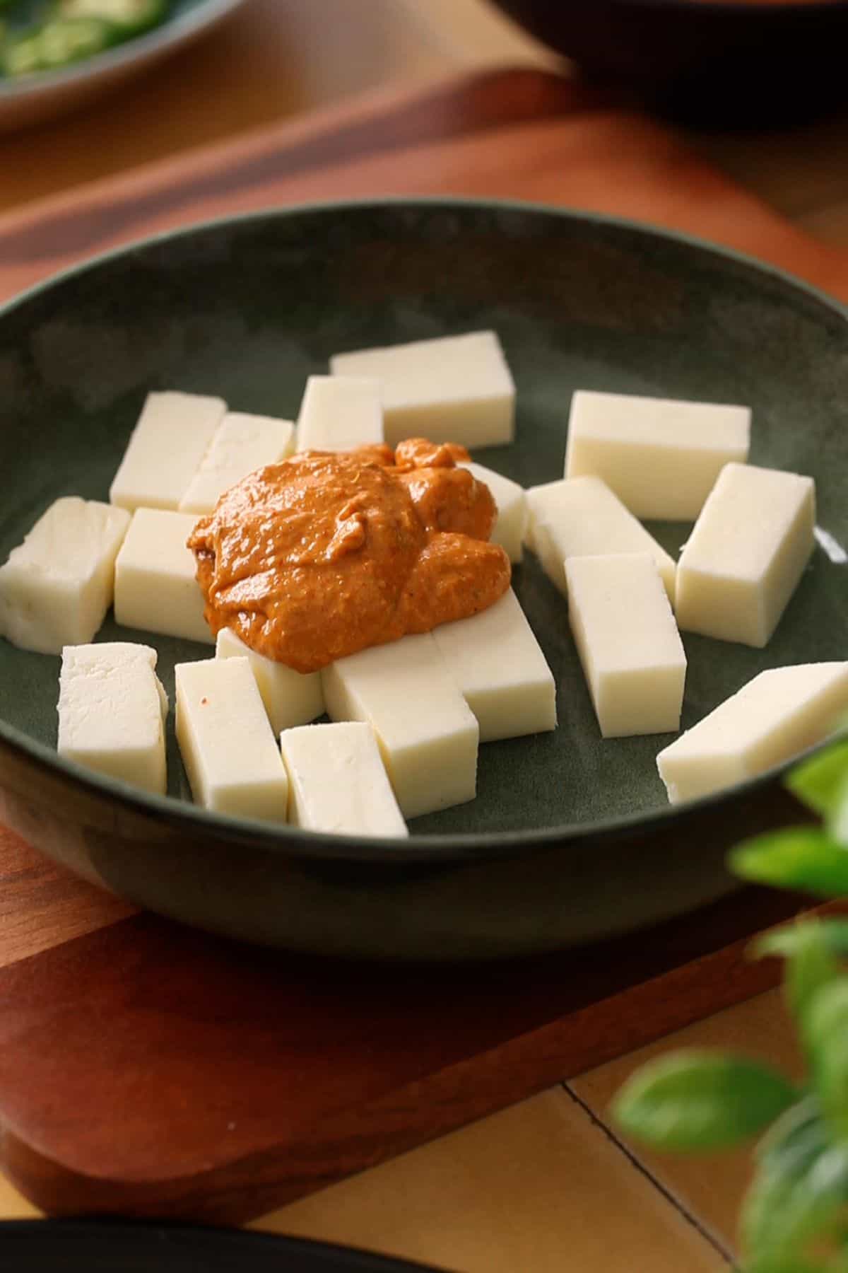 Marinade is added on top of paneer cubes.