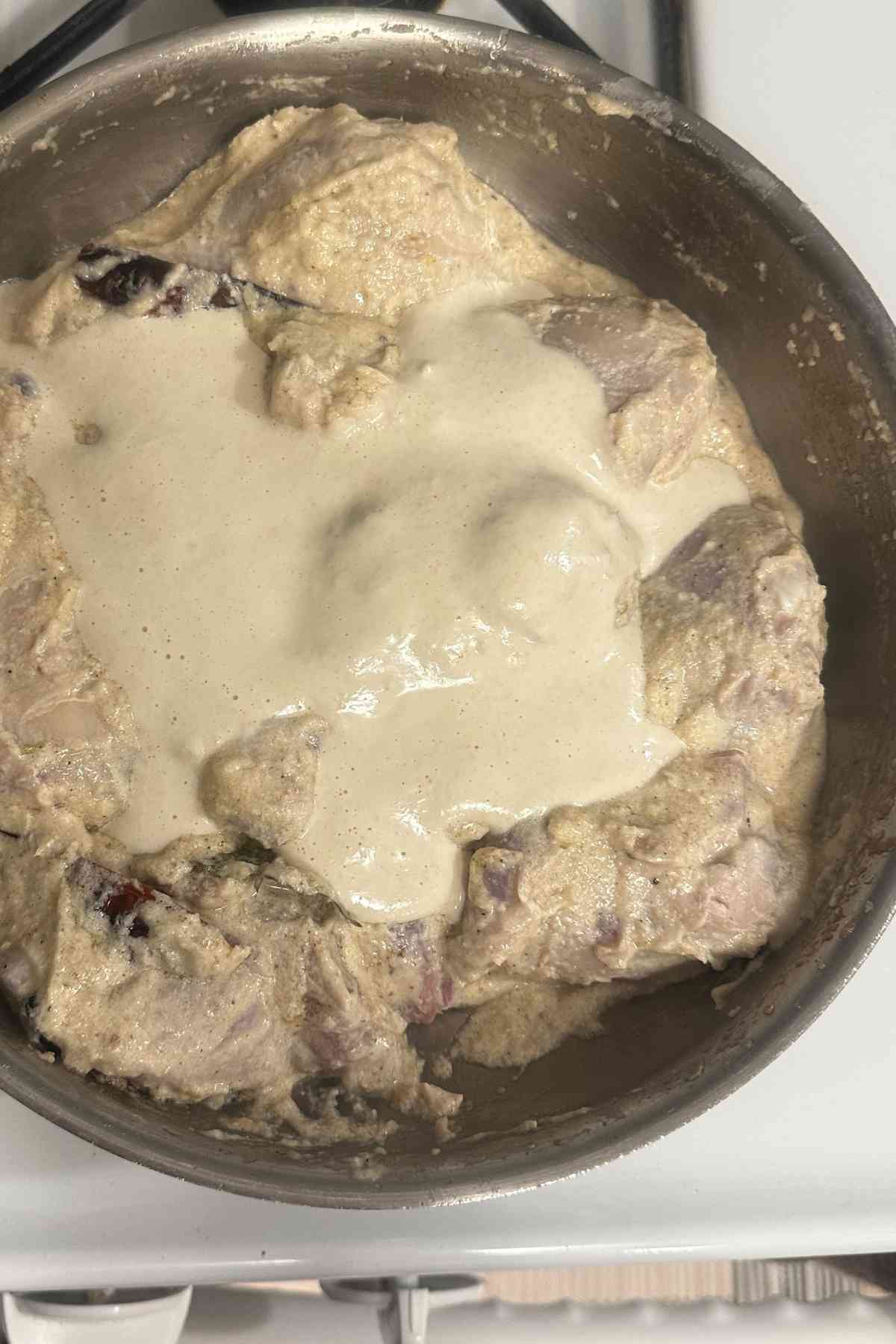 Adding cashew paste to the chicken rezala. 