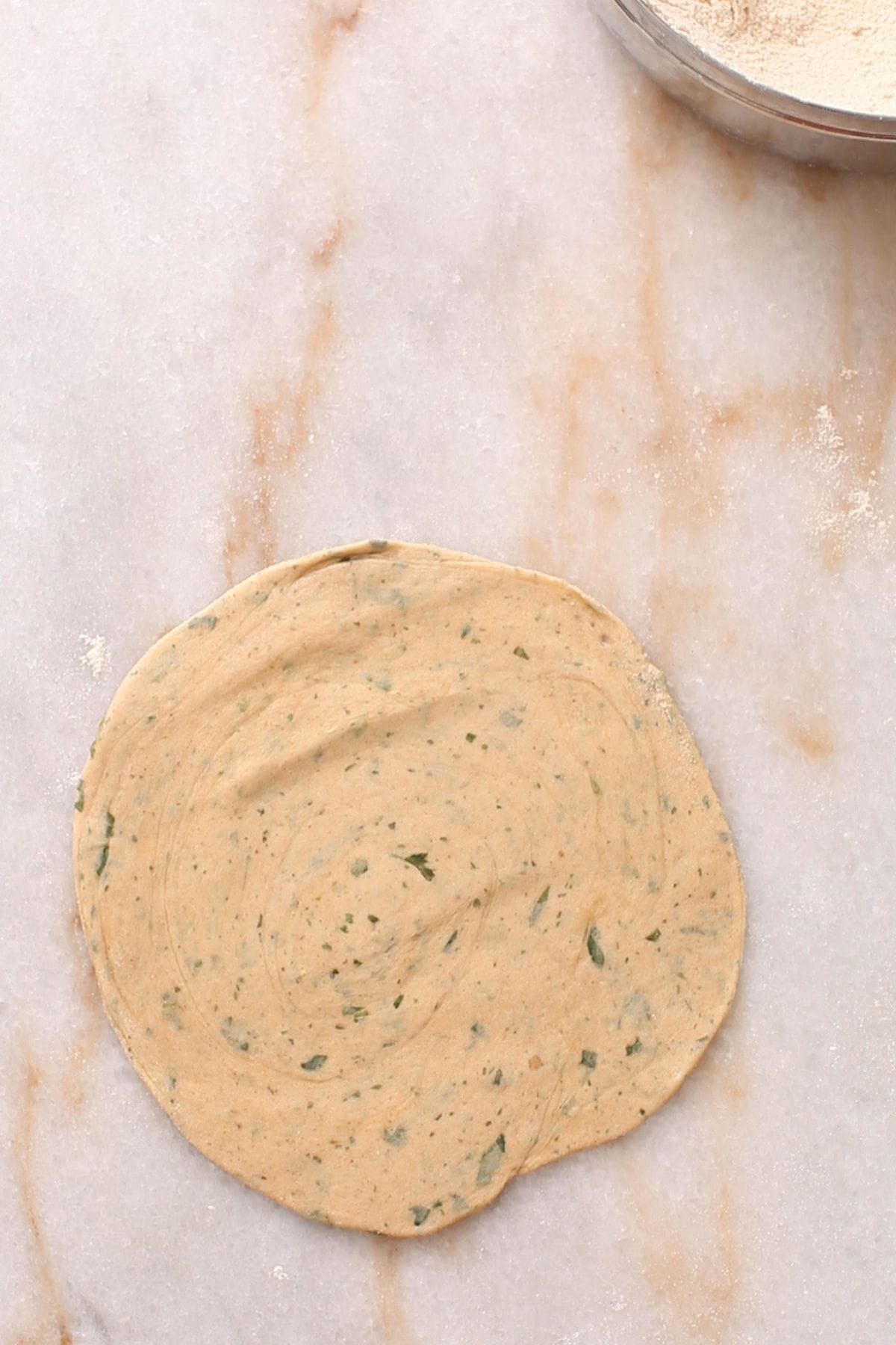 Rolled laccha pudina paratha on a marble surface.