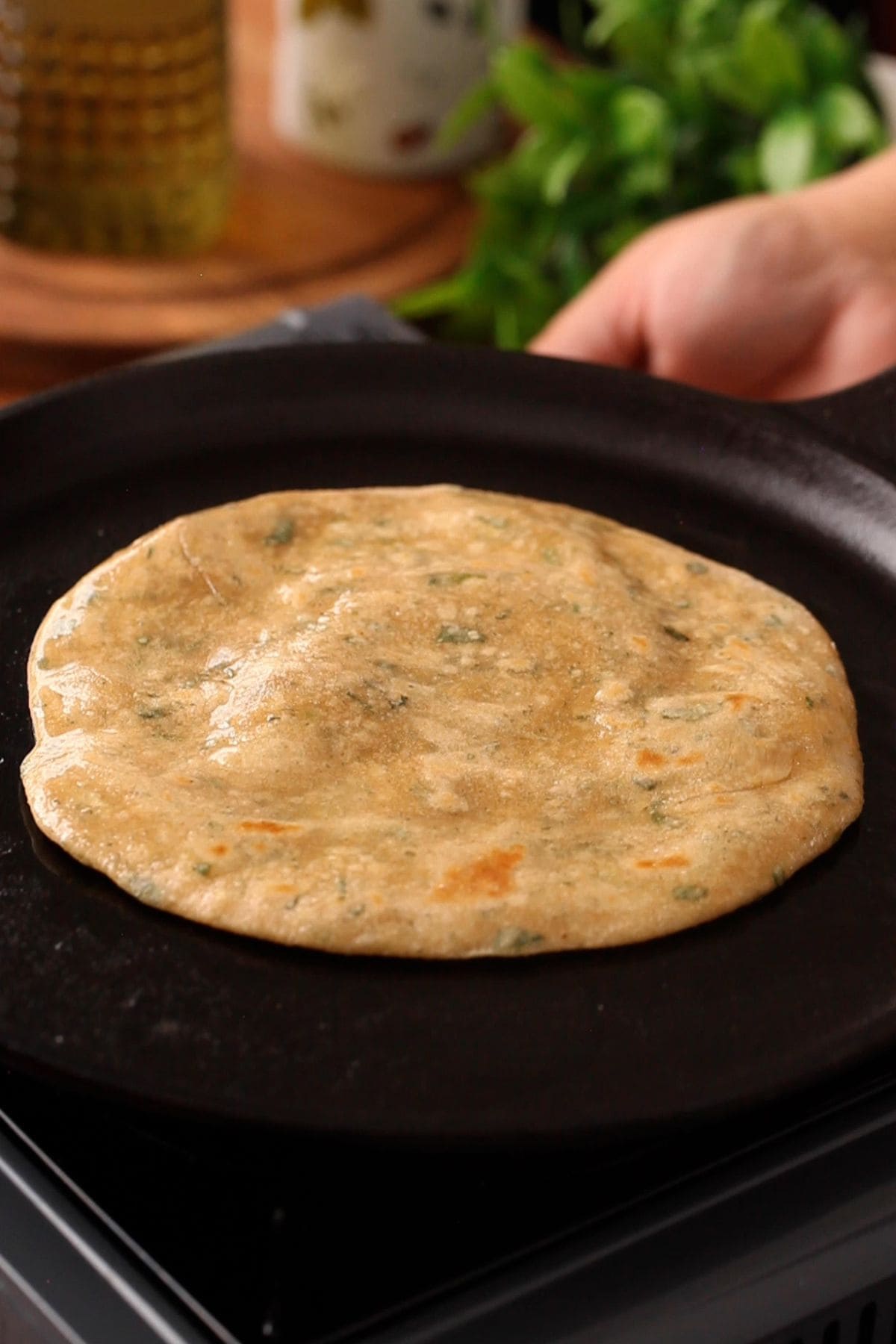 Oil is smeared on laccha mint paratha to cook it. 