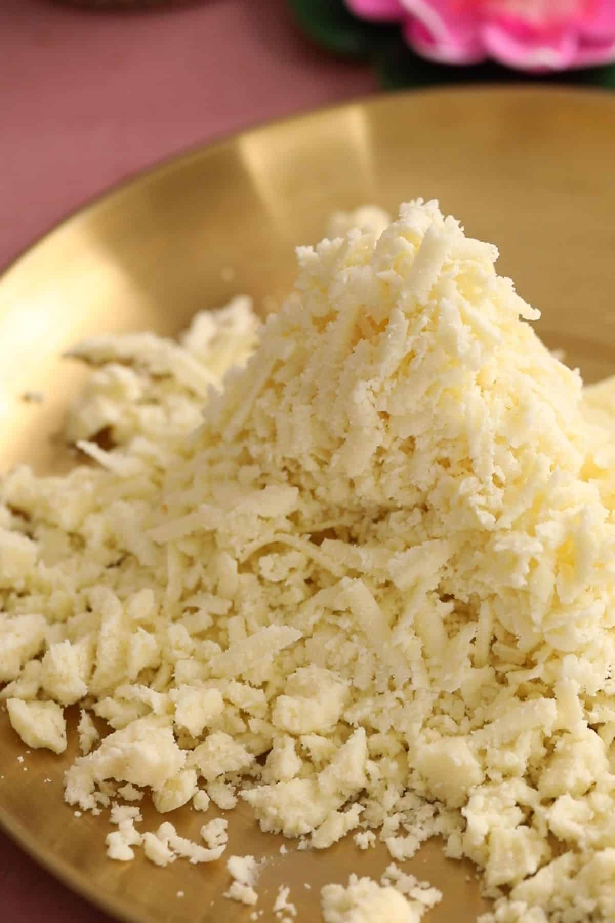 Grated mawa in a gold plate.