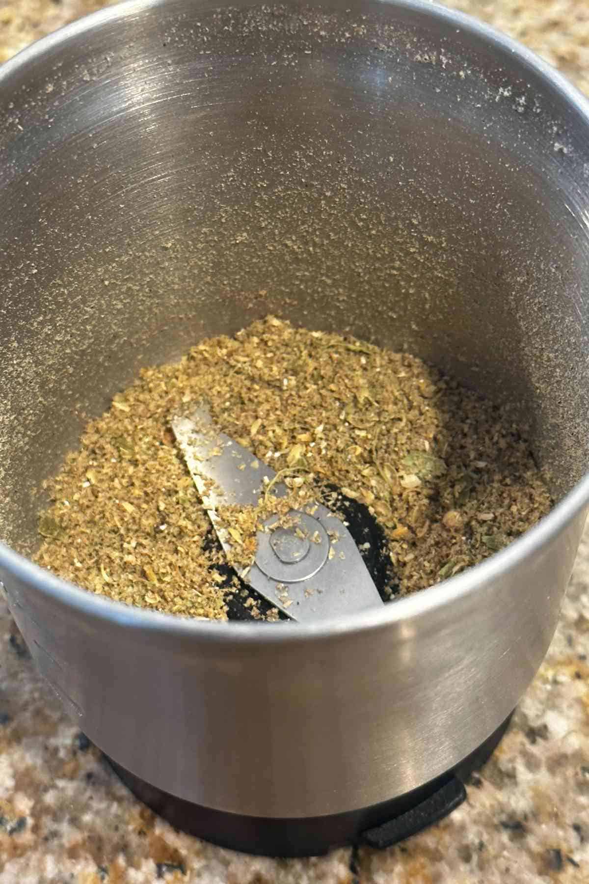 Grinding fresh spice powder for making chicken rezala.