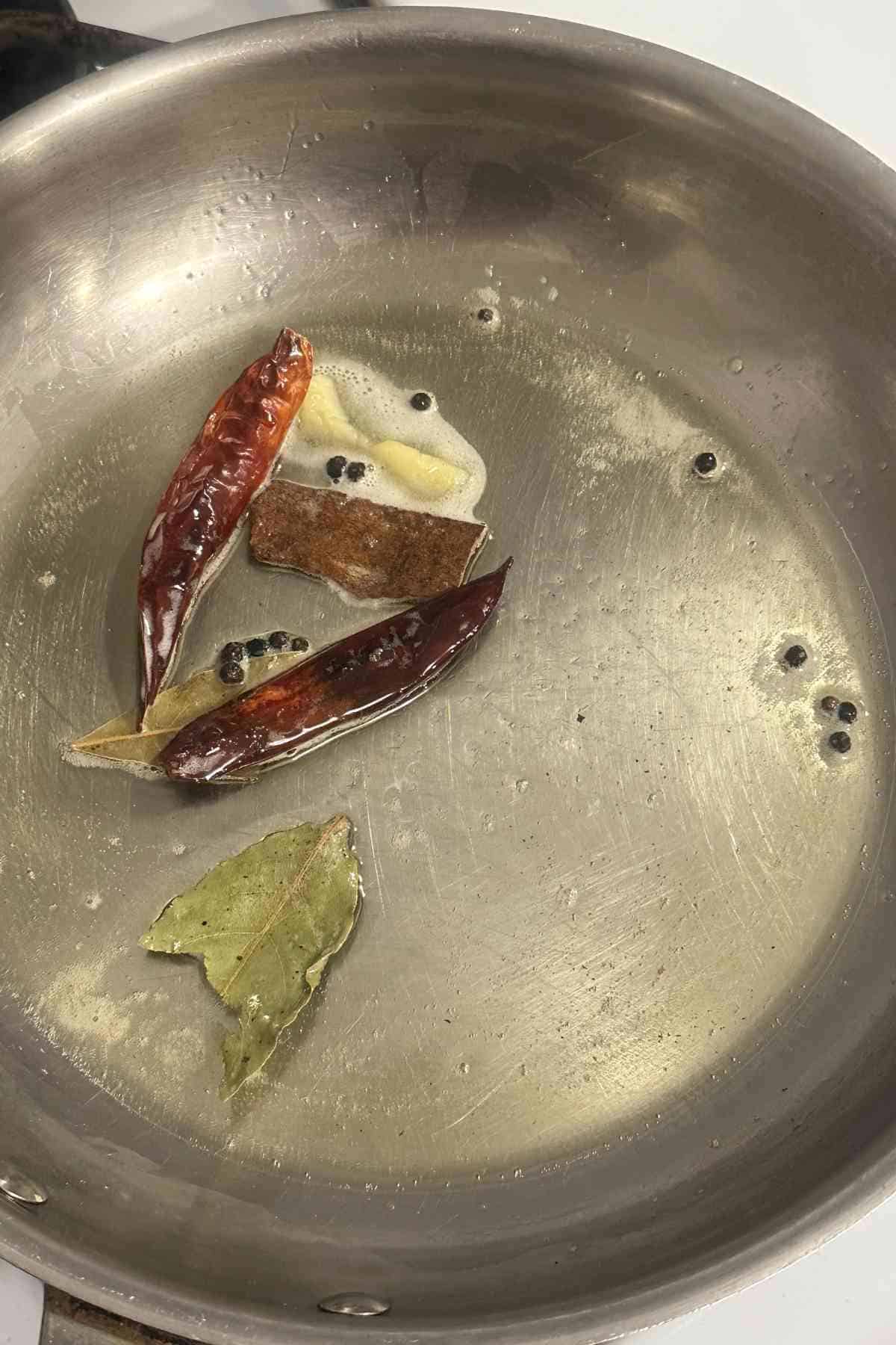 Tempering ghee with whole spices. 