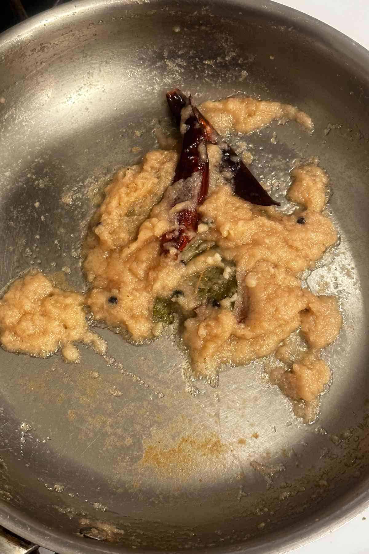 Cooking onion paste till its light brown.