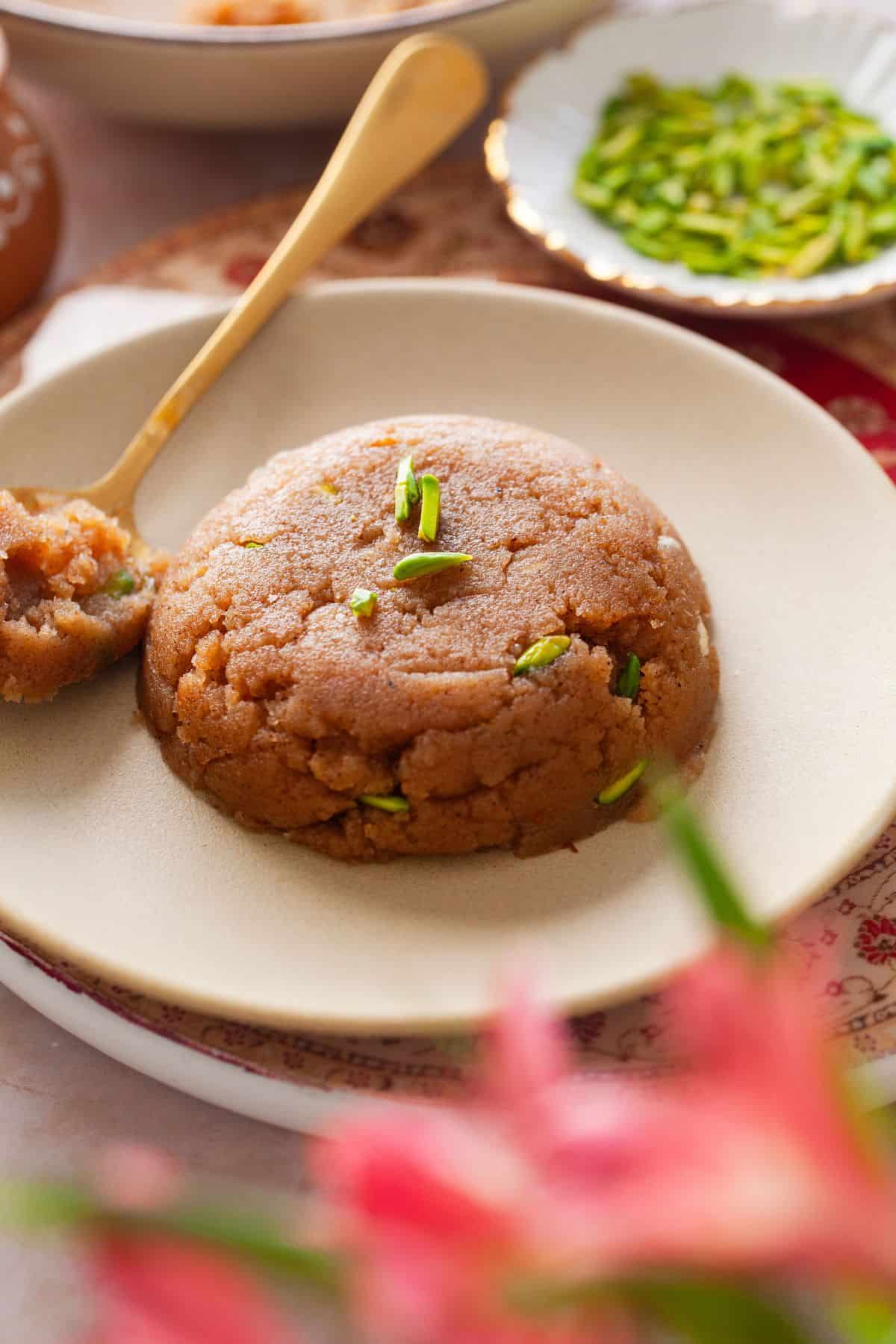 Sooji halwa is served on a beige plate.