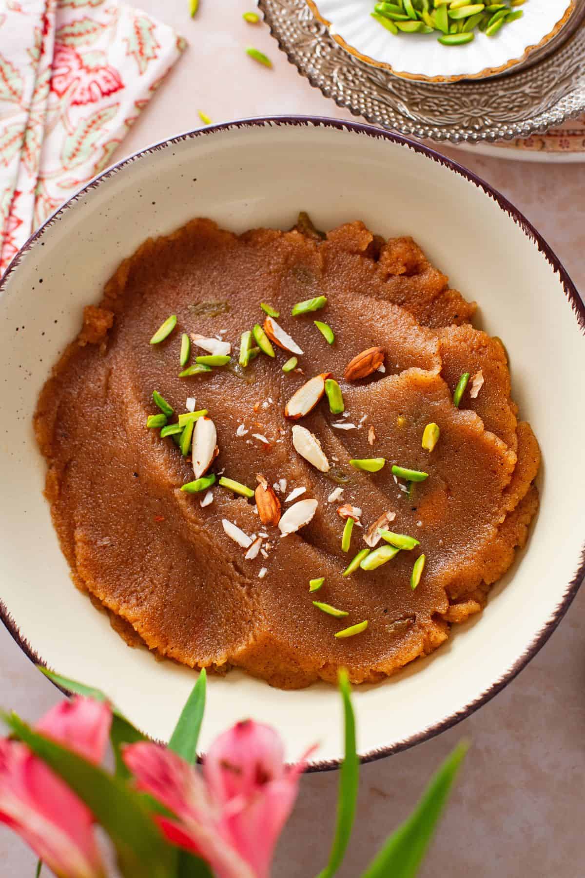 Overhead image of suji halwa served garnished with nuts.