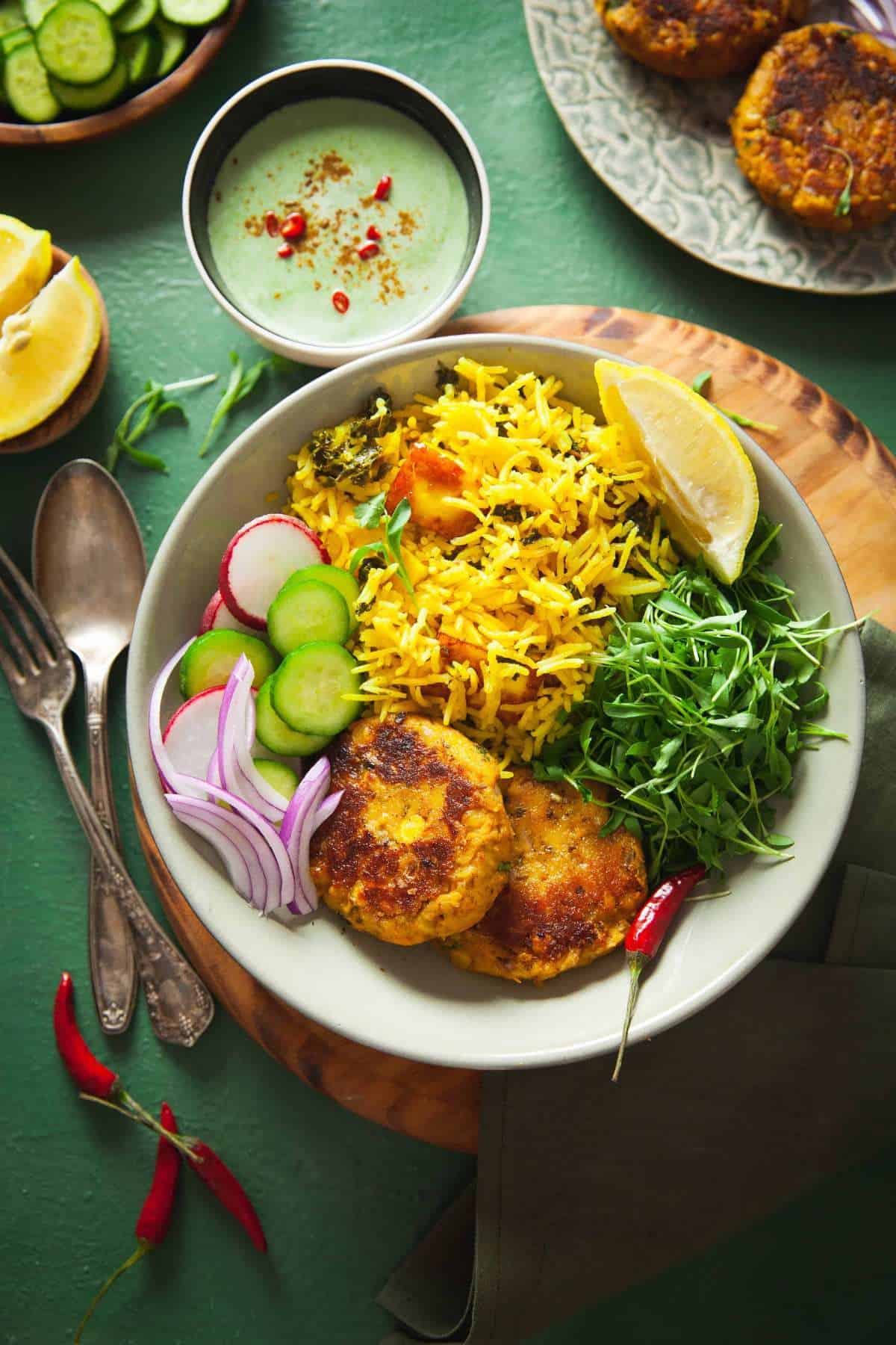 Indian buddha bowl of lentil patties with rice pulao and micro greens.