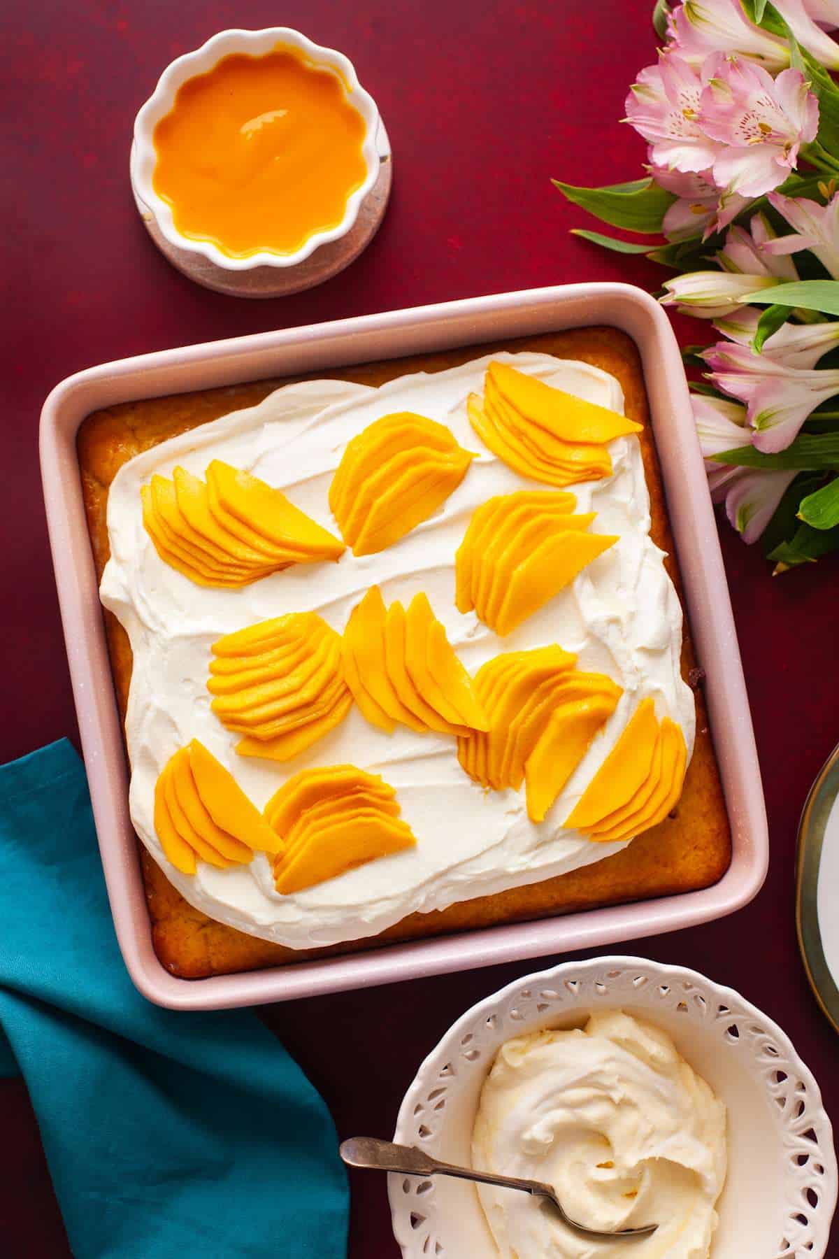 Top view of tres leches cake made with fresh mangoes topped with whipped cream.