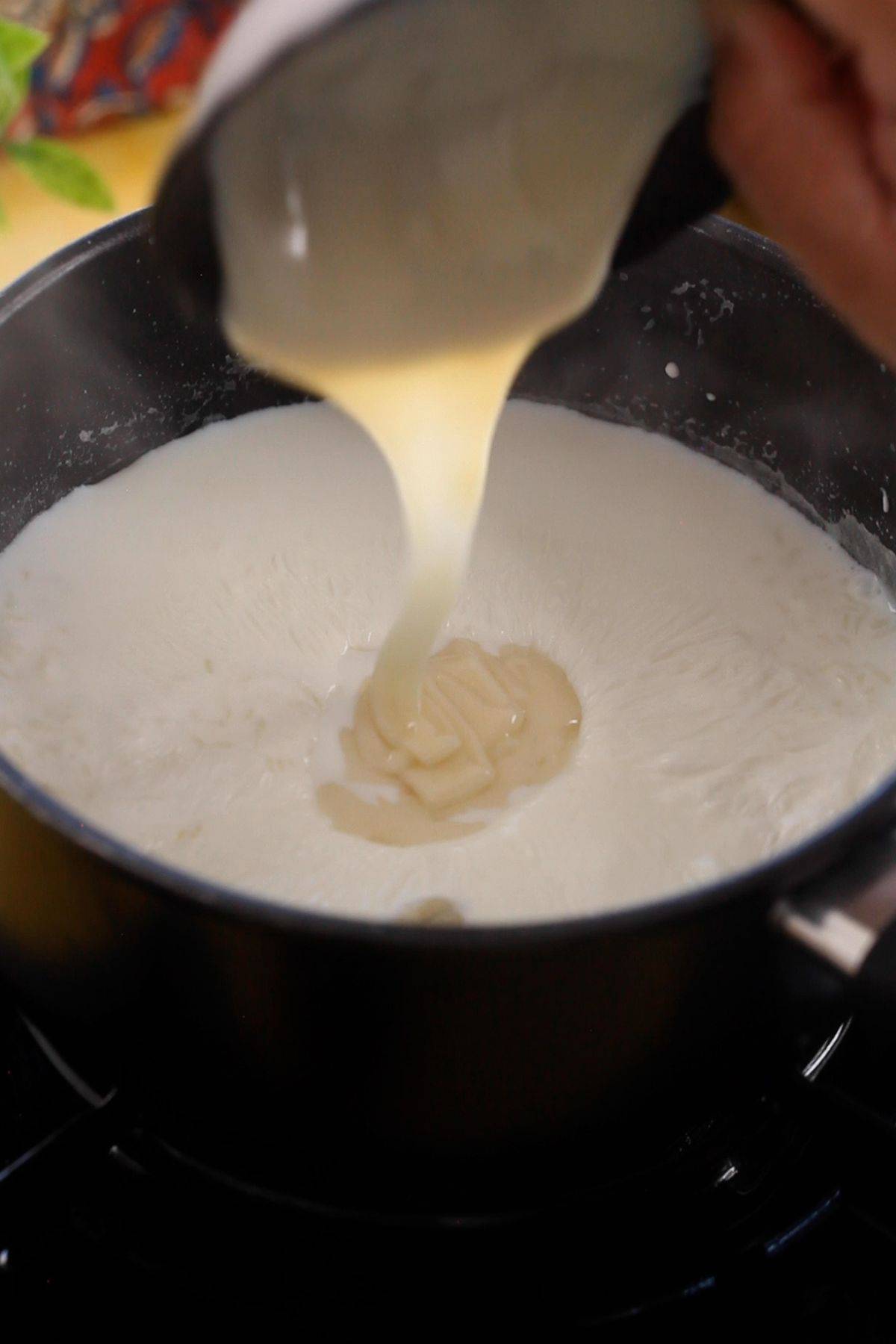 Adding sweet condensed milk to kheer.