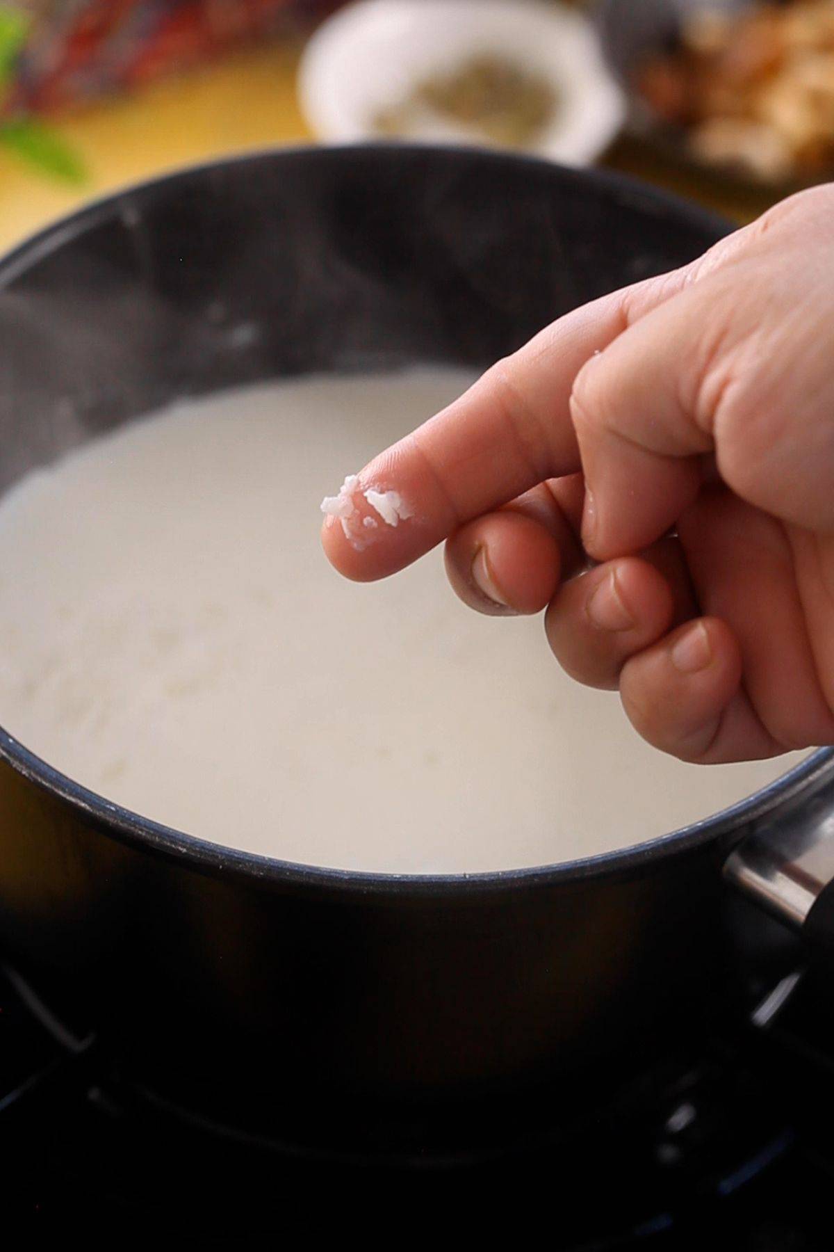 Checking doneness of rice by smushing it with fingers.