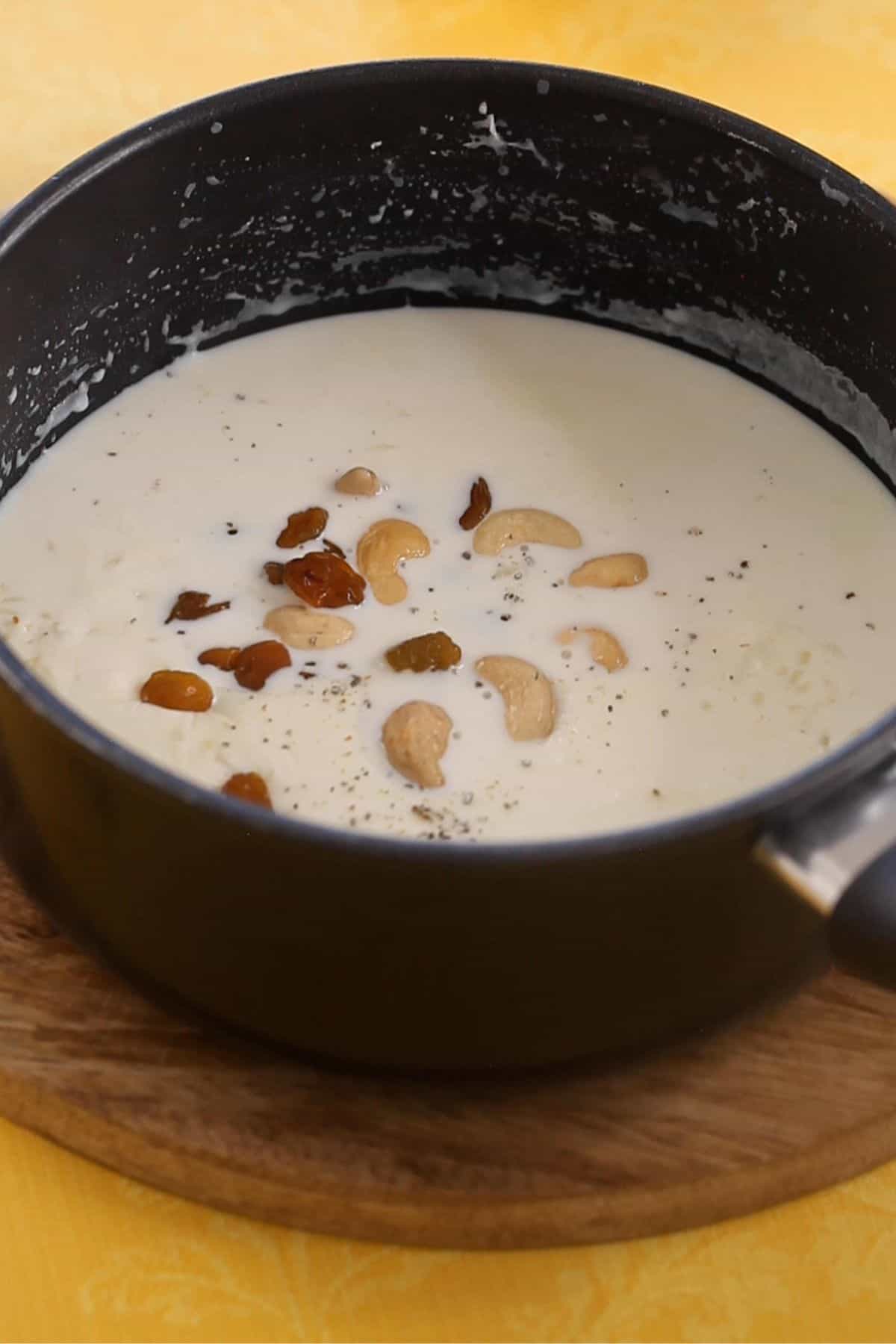 Cardamom powder, raisins and fried cashews are added to kheer to finish. 