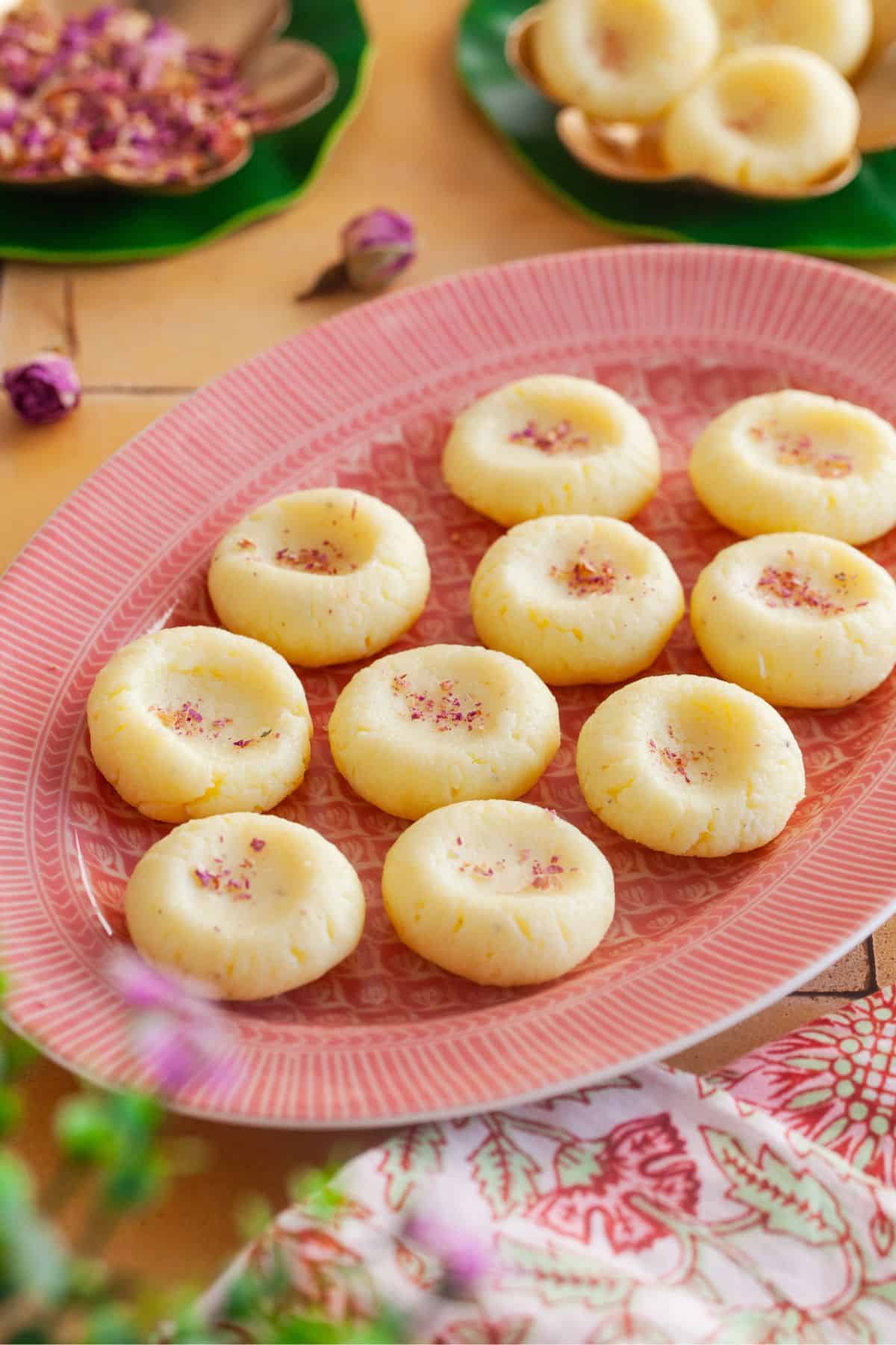 Malai peda served on a pink oval plate. 