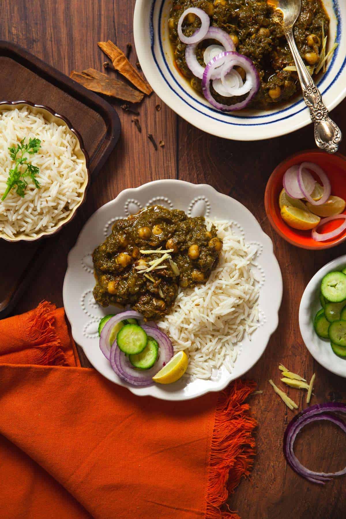 Chole Palak served on a white plate along with fresh salad.