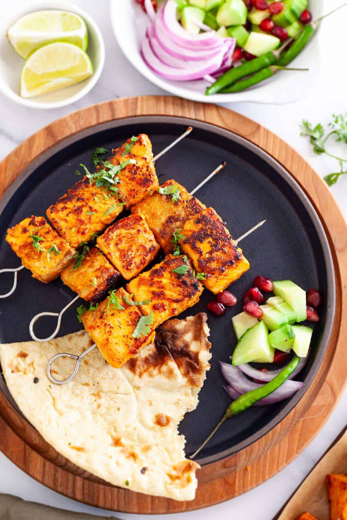 Tandoori Fish tikka served on a black plate.