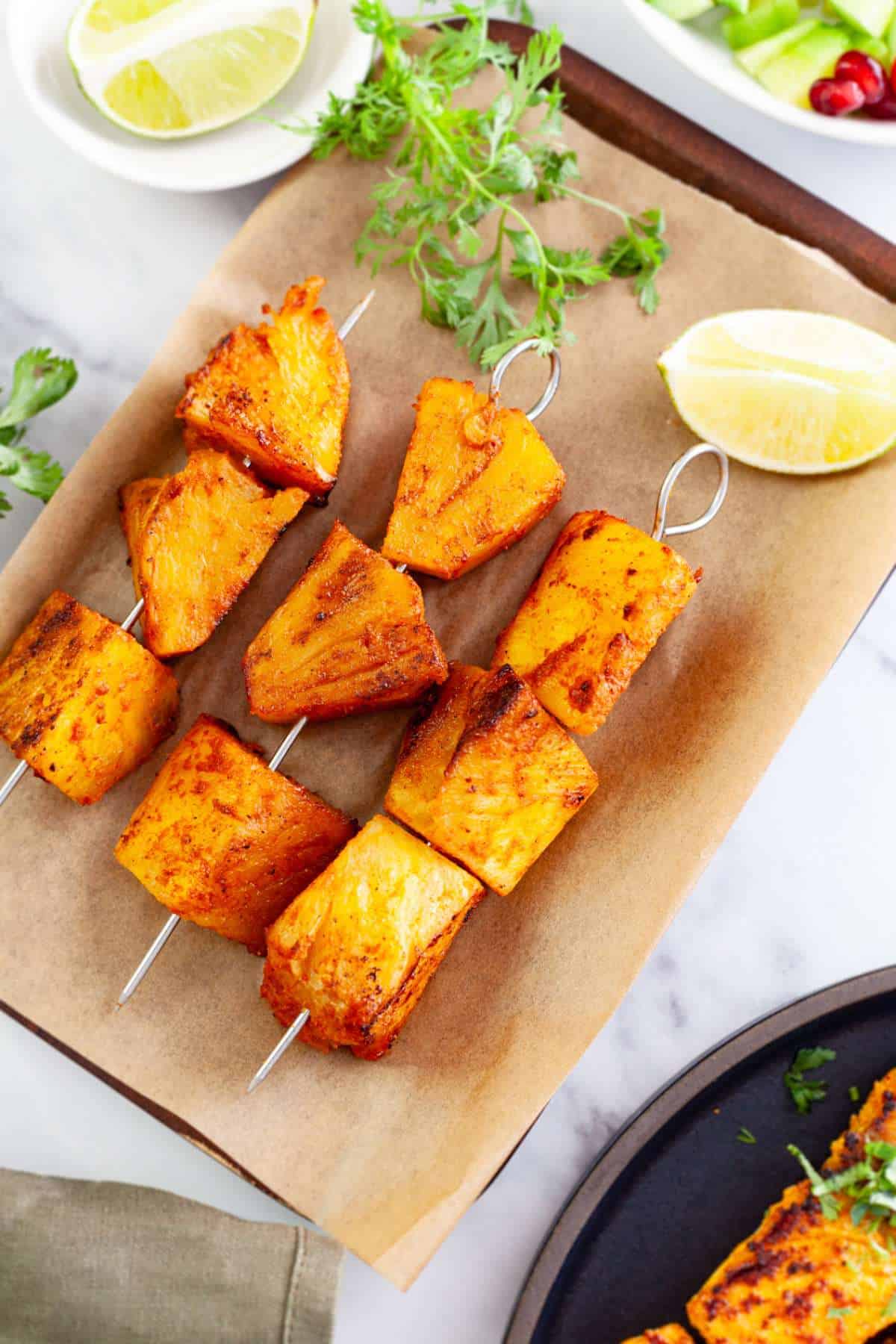 Tandoori pineapple tikka served with lemon and cilantro.
