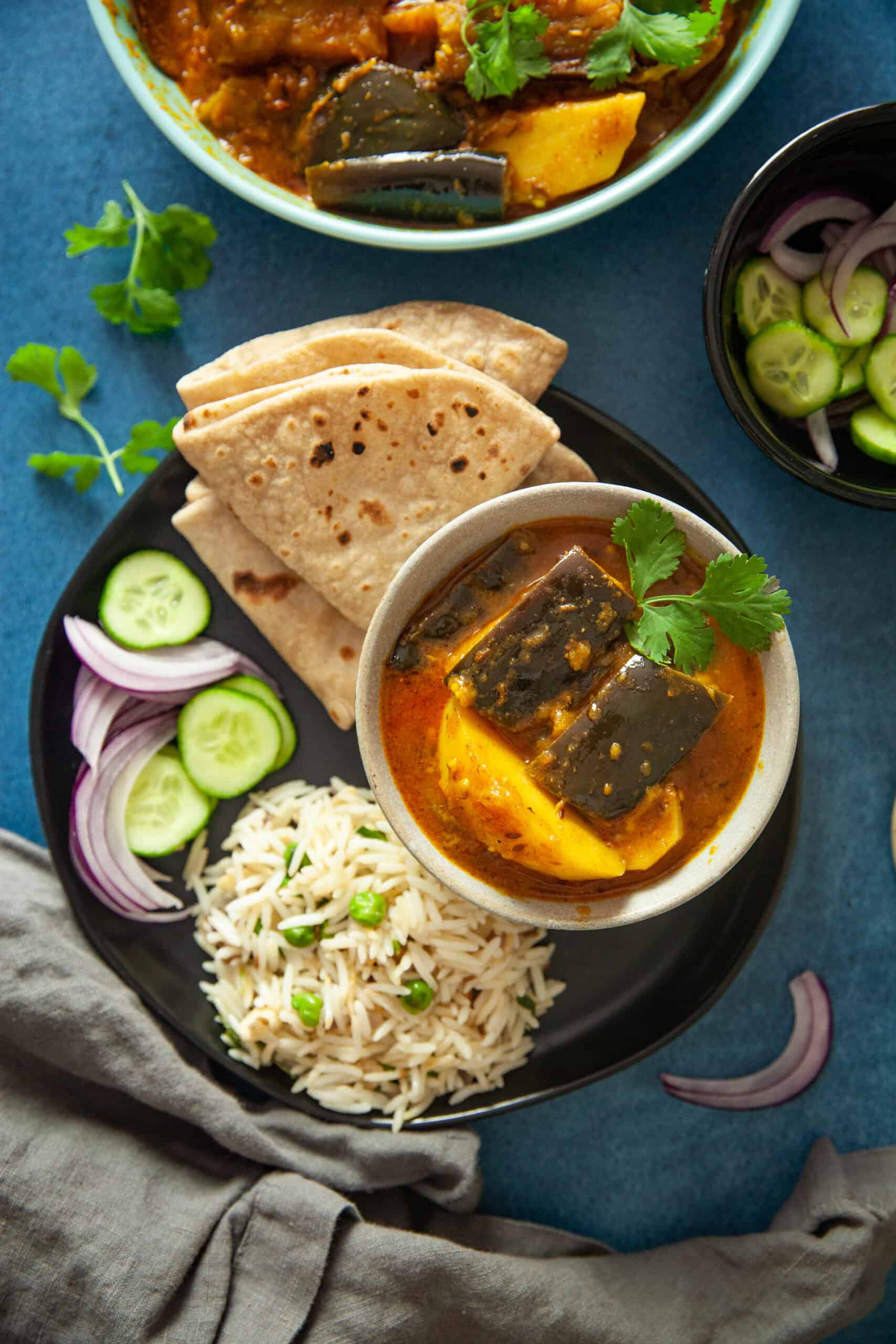 Baingan Aloo in a able bowl served with flatbread.