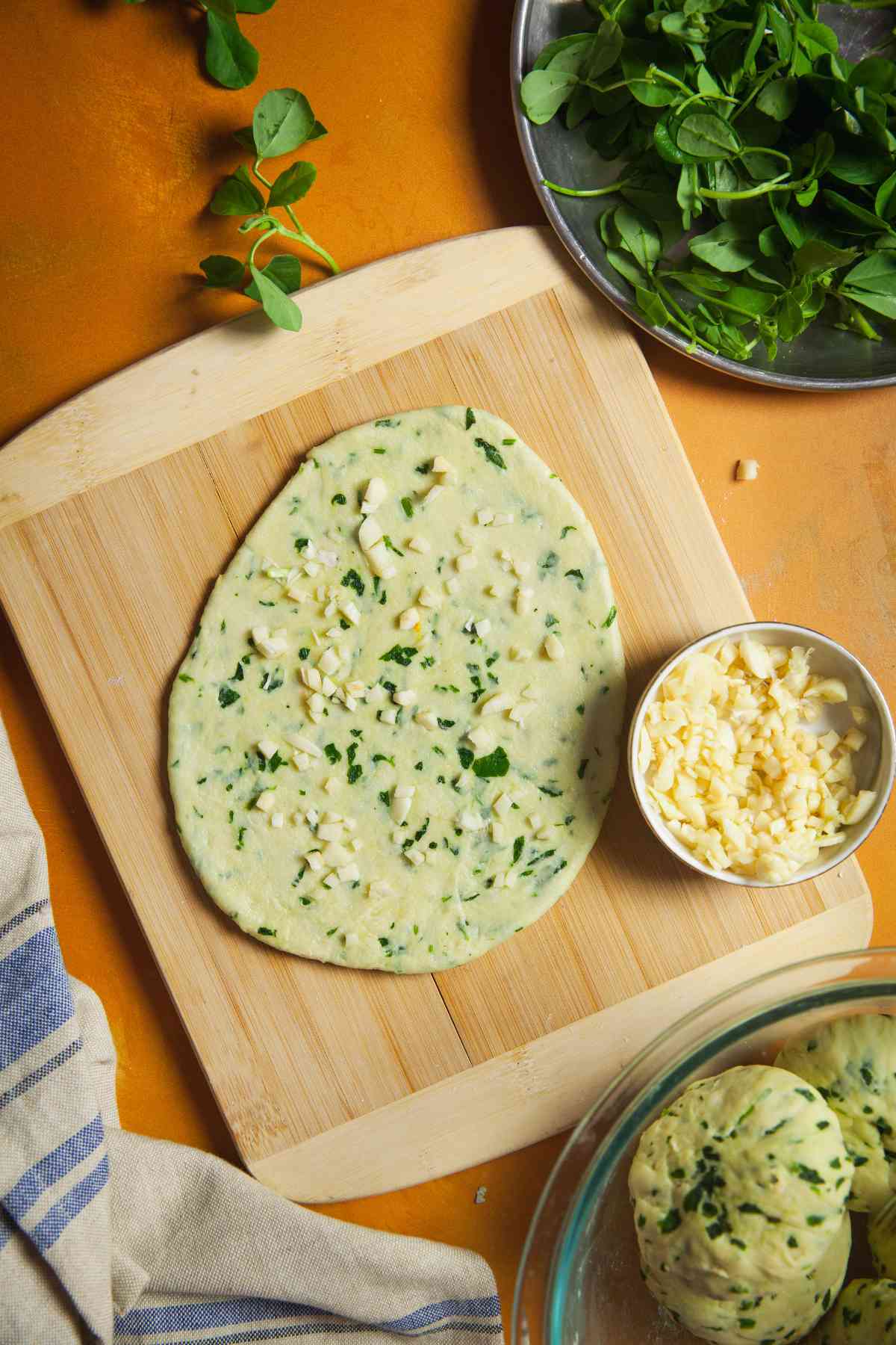 Chopped garlic pressed on the rolled naan.