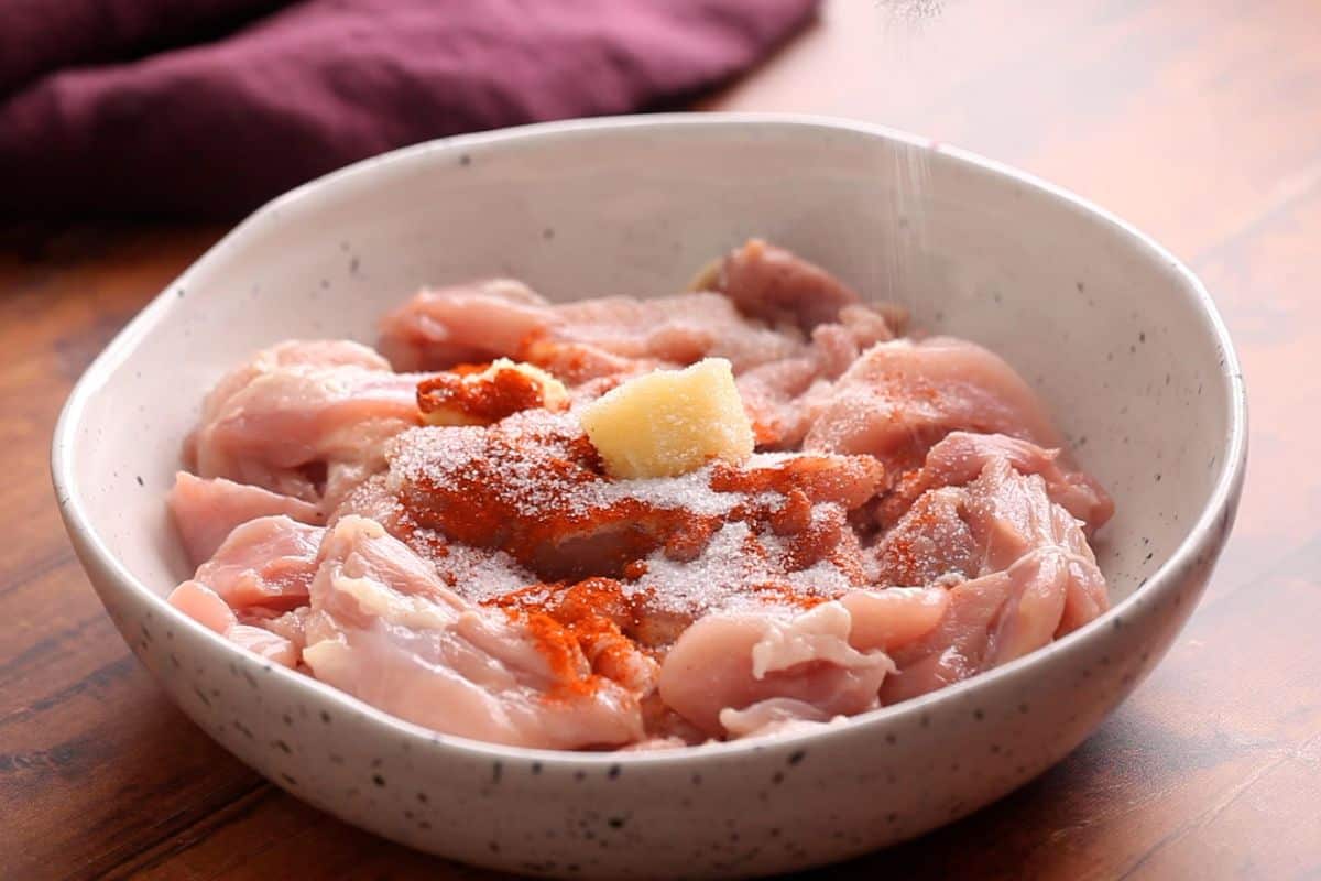 Marinating chicken in garlic,salt and red chili powder.