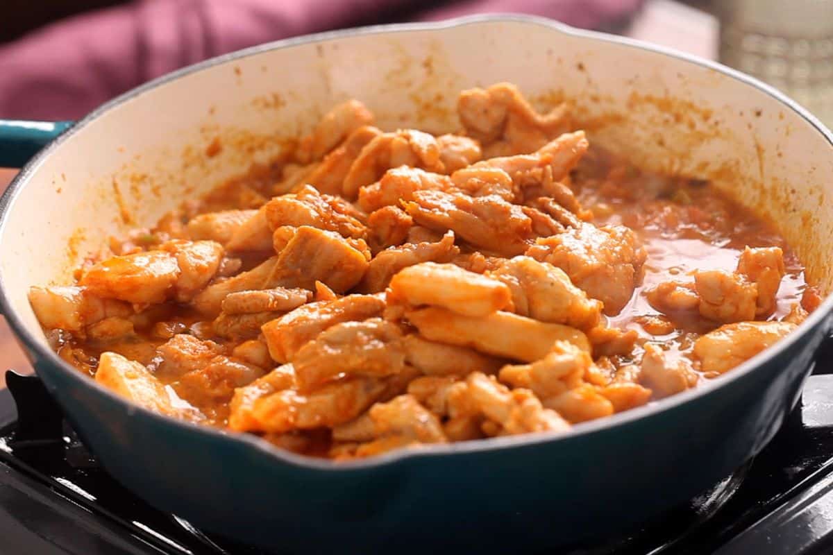 Chicken is aaded to the onion and tomatoes in the tawa.