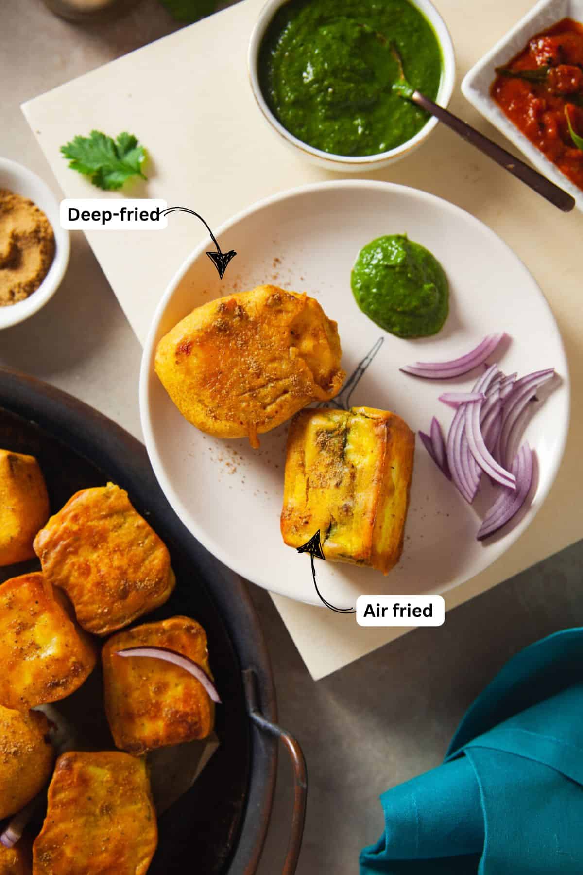 An image showing air fried and deep fried paneer pakoras served on a small white plate with green chutney.