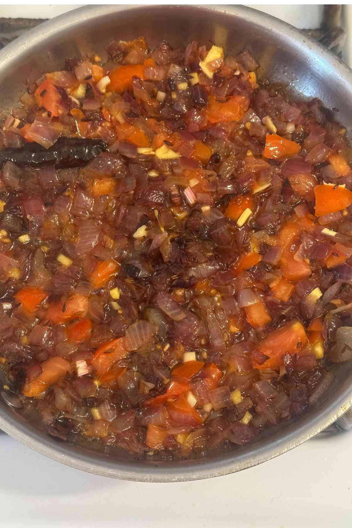 Making tadka for saag in a skillet.