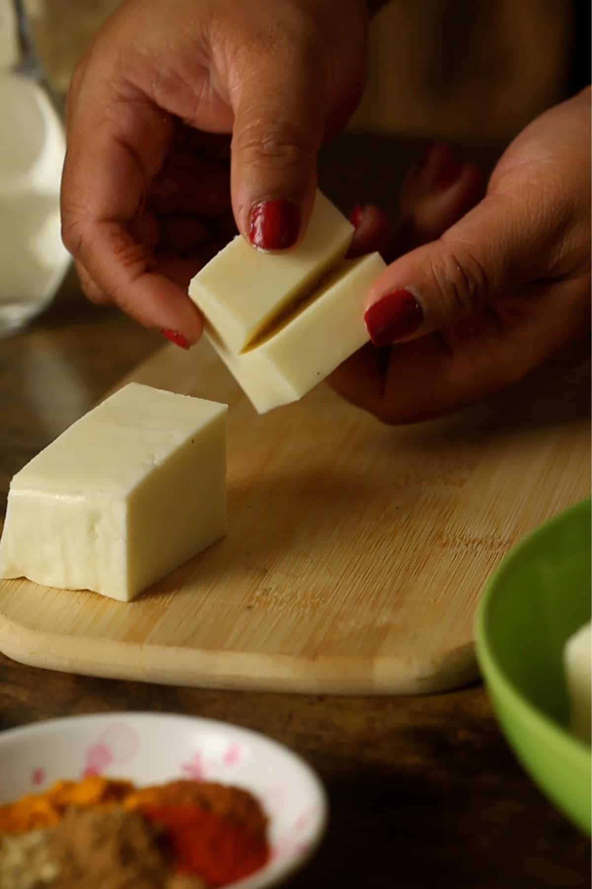 A cube of paneer is hown with gap for stuffing the chutney.