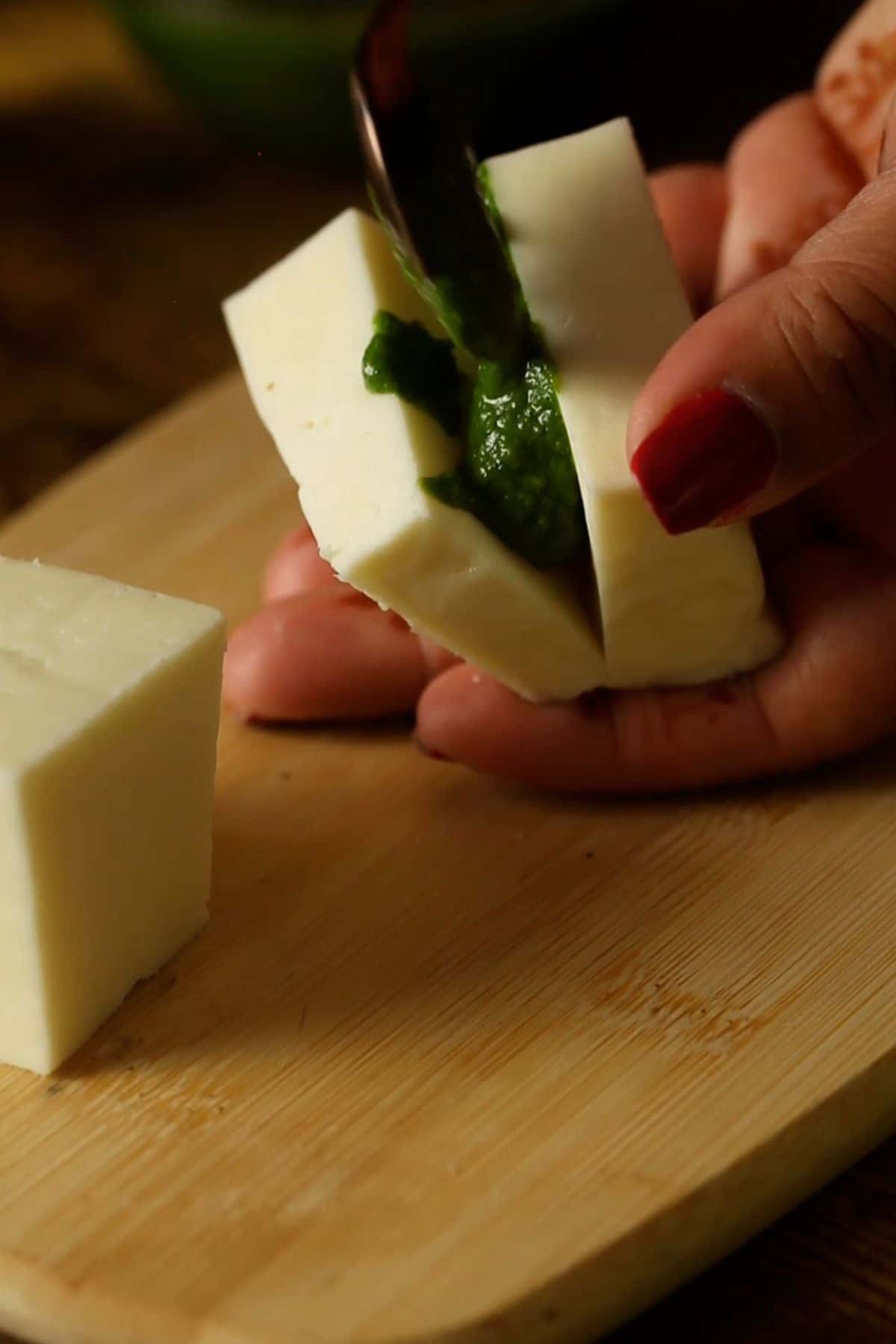 Green chutney is being stuffed inside the paneer pakora.