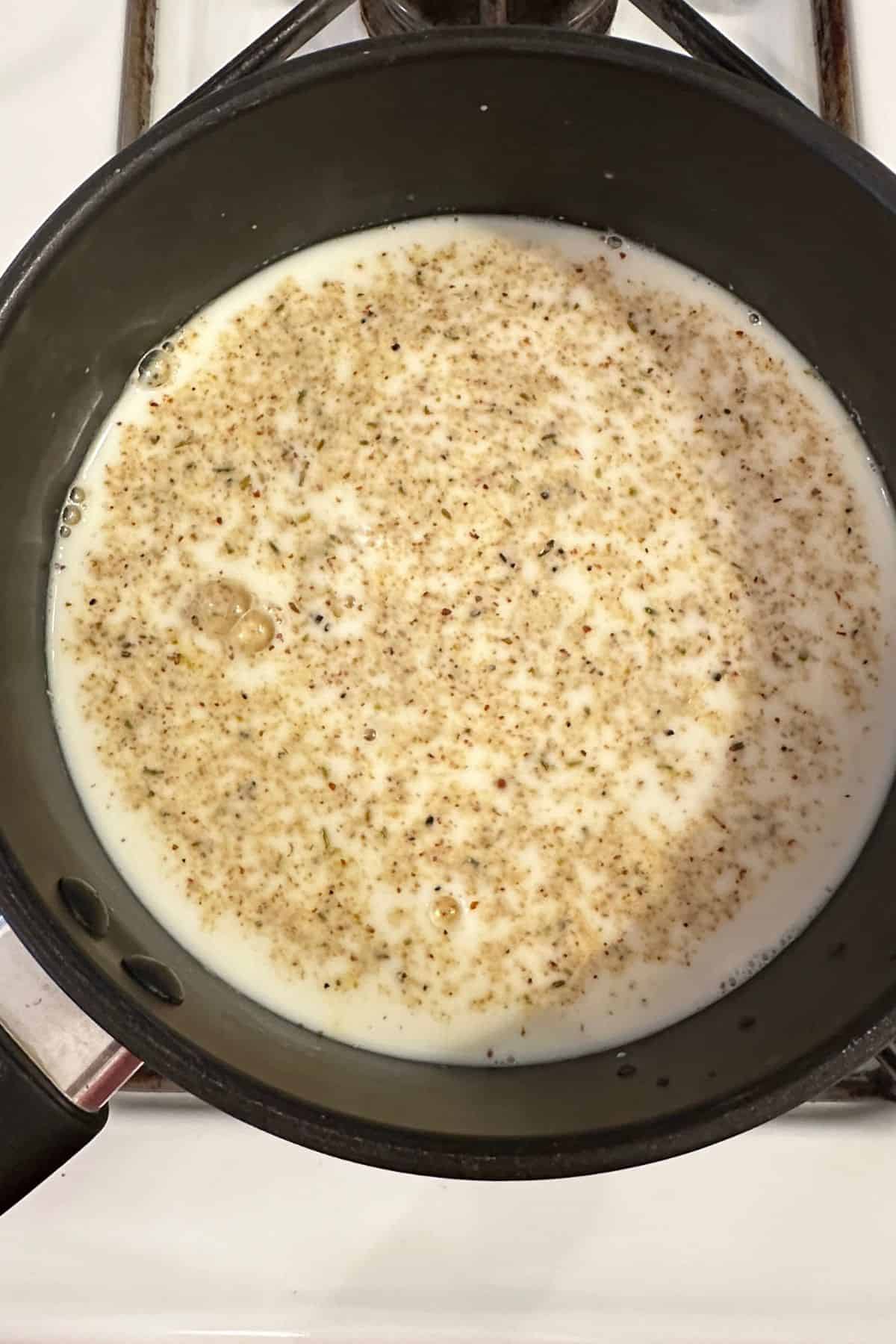 Milk with thandai masala set on stove.