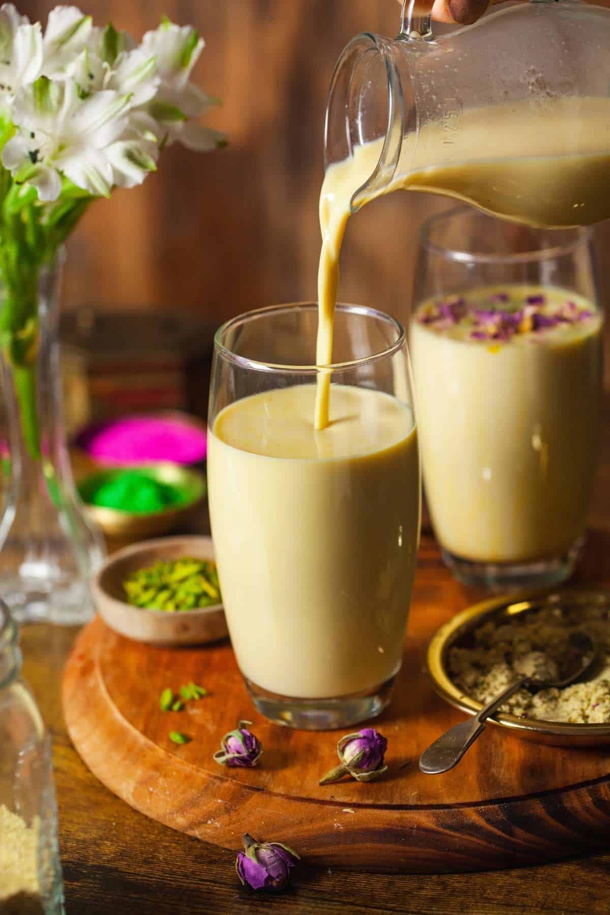 Thandai being poured into glasses.