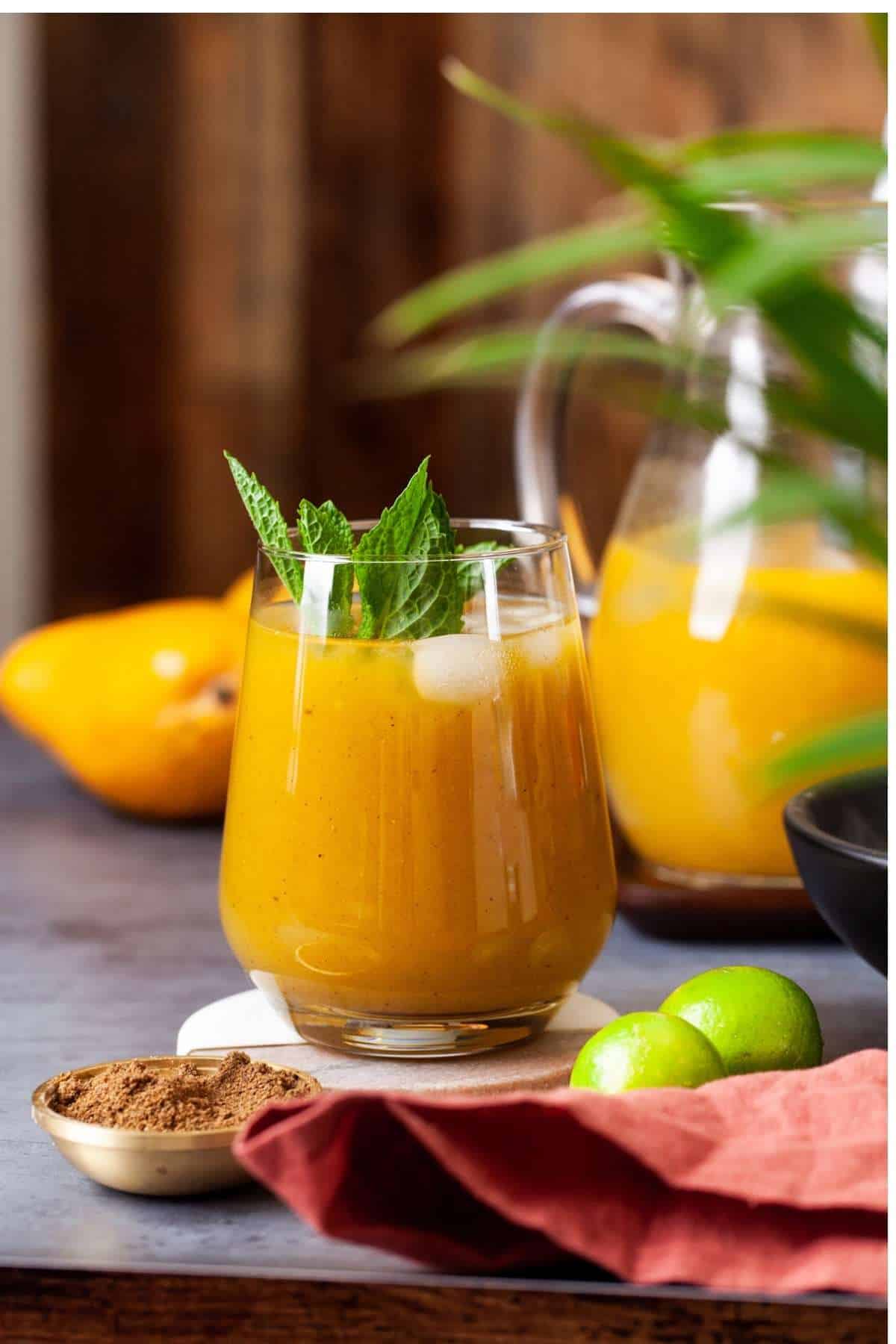 Mango Shikanji over ice in a glass and garnished with mint leaves. 