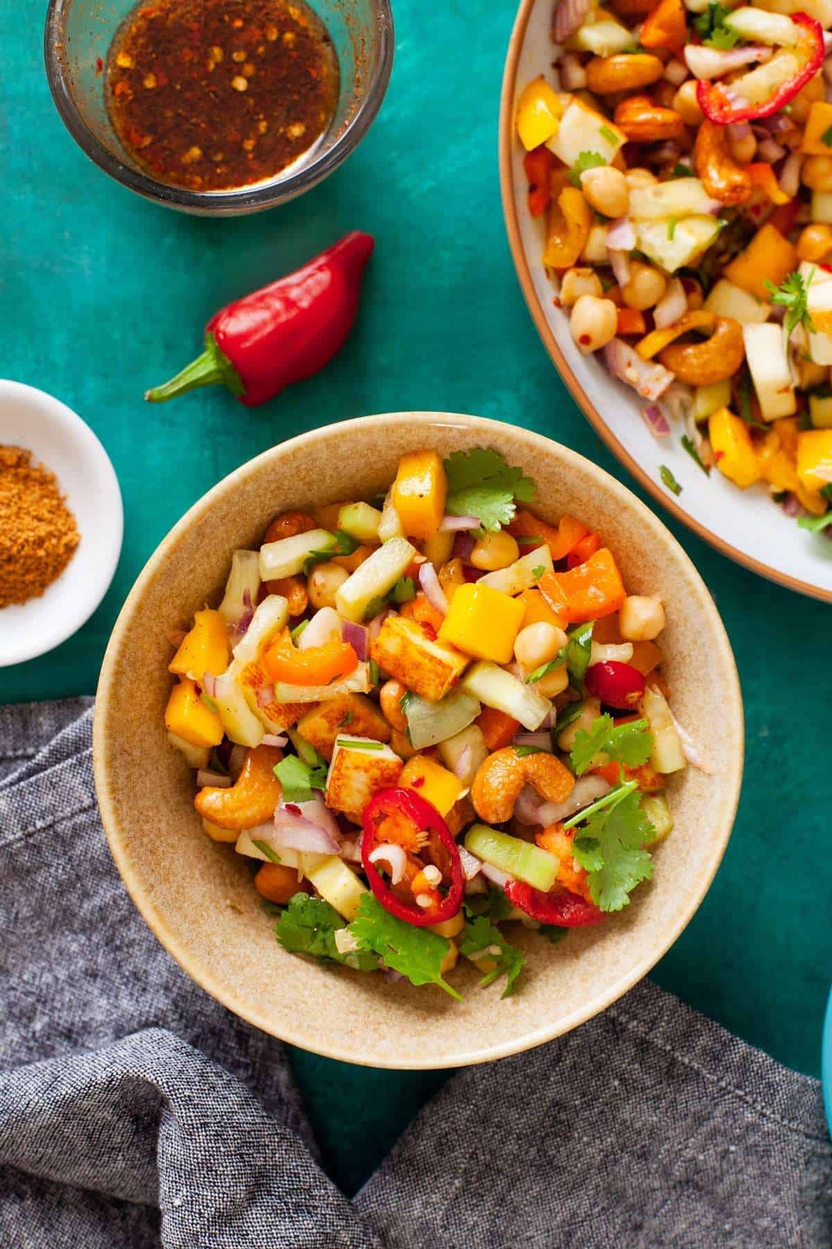 Paneer Salad in a beige bowl placed over green background. 