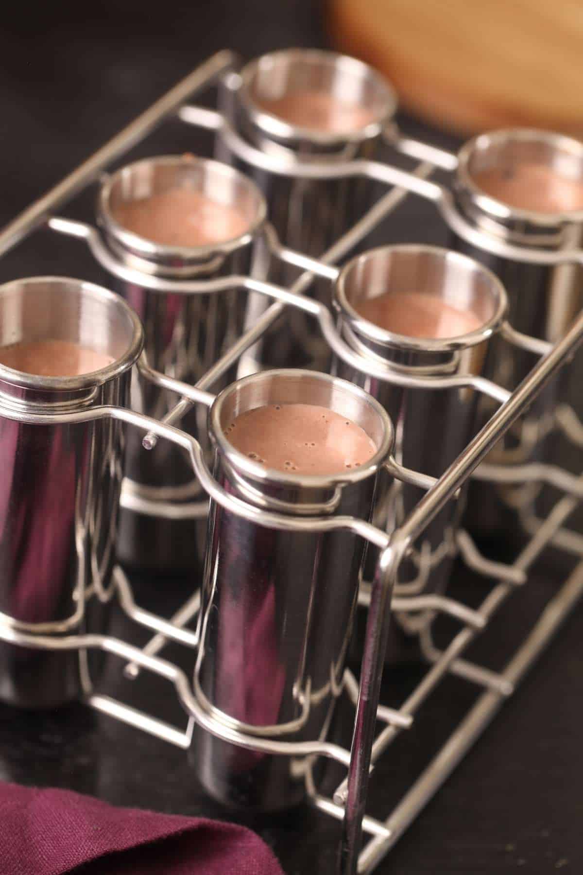 Milk mixture filled in kulfi moulds. 