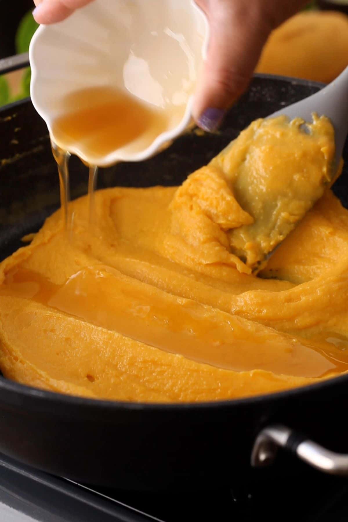 Ghee is added to mango burfi mixture.