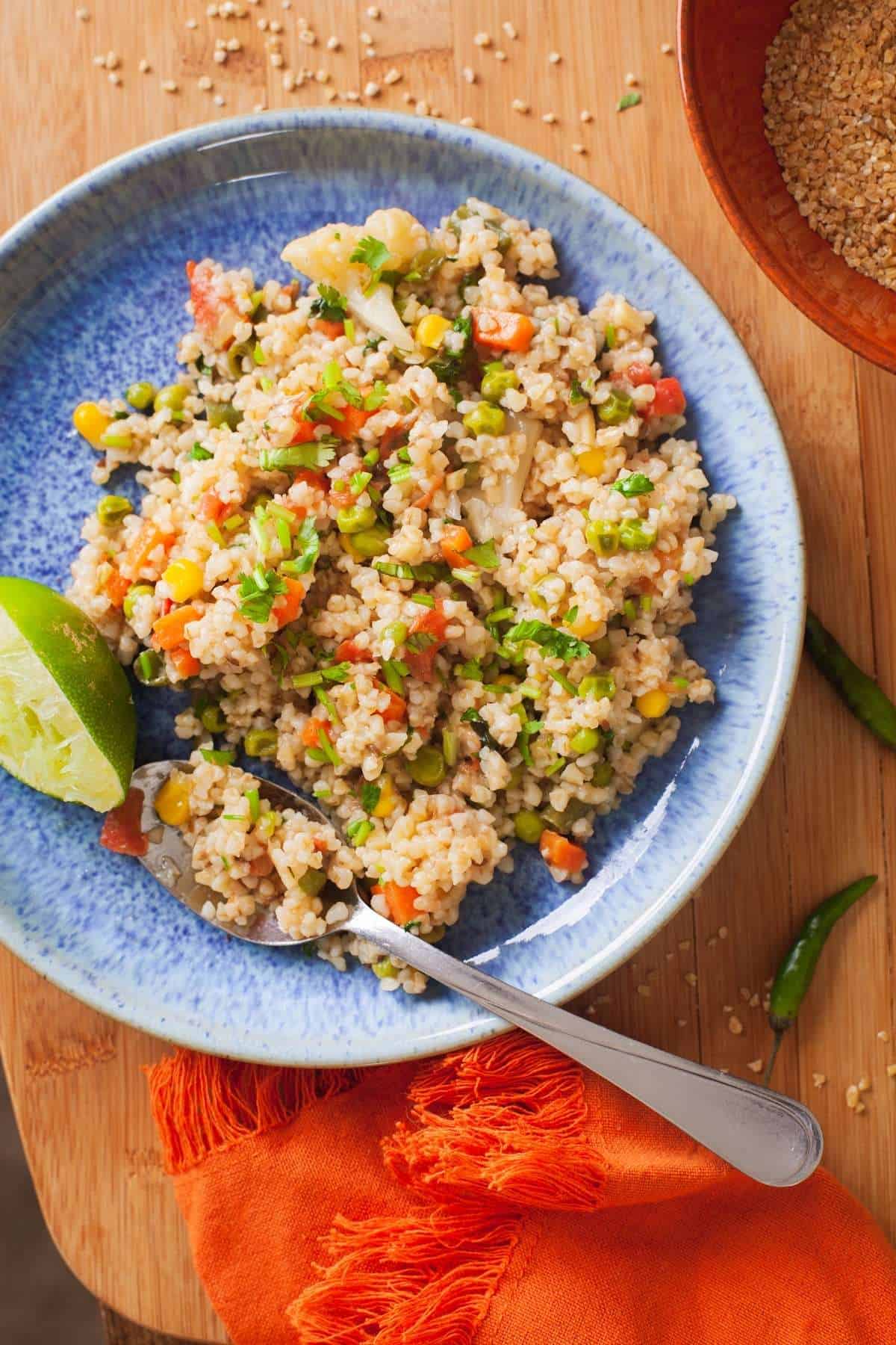Dalia Upma With colorful vegetables in a blue plate. 